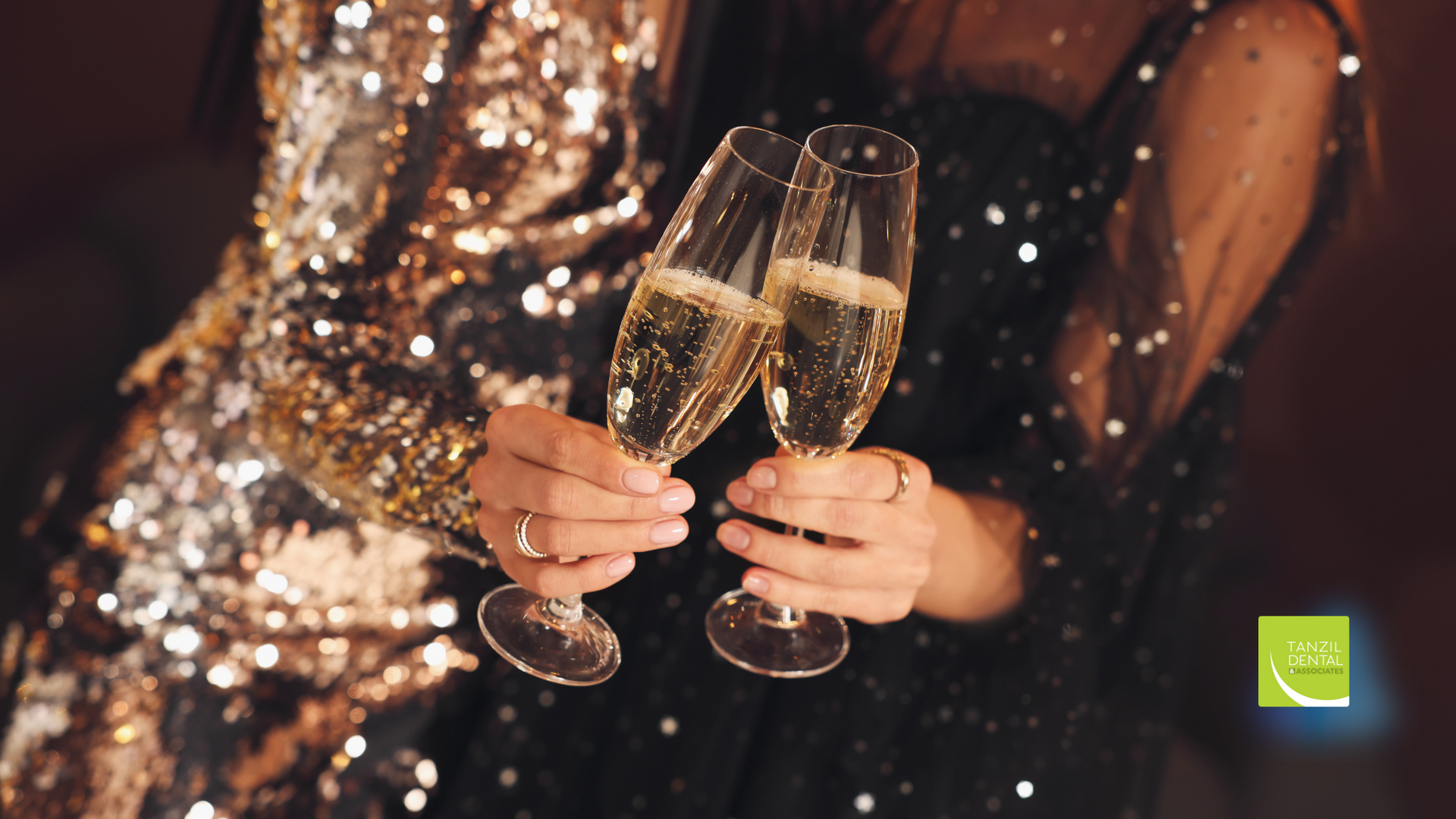A woman in a sequined dress is holding two glasses of champagne.