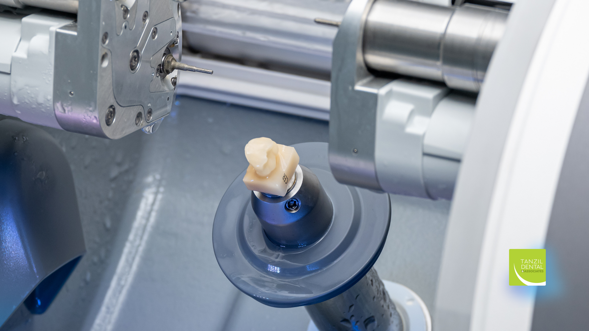 A machine is making a dental crown on a table.
