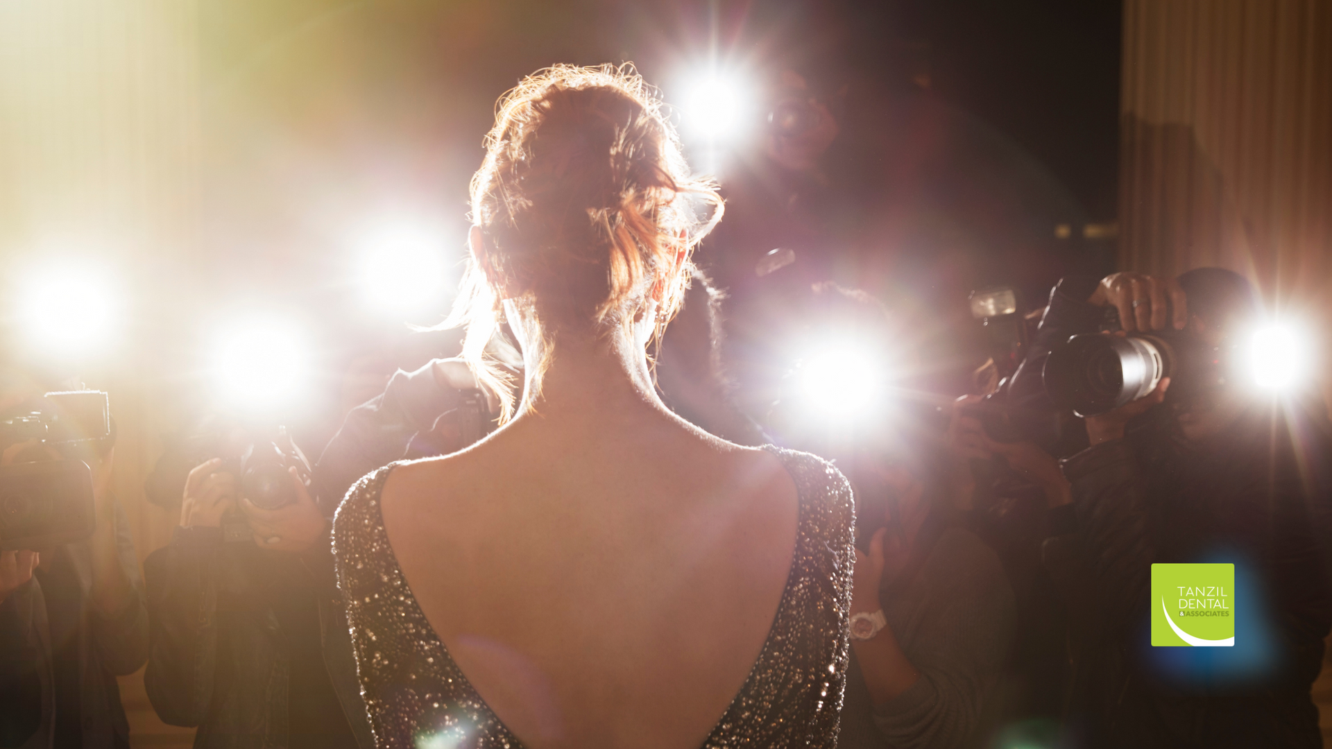 A woman in a dress is standing in front of a crowd of people.