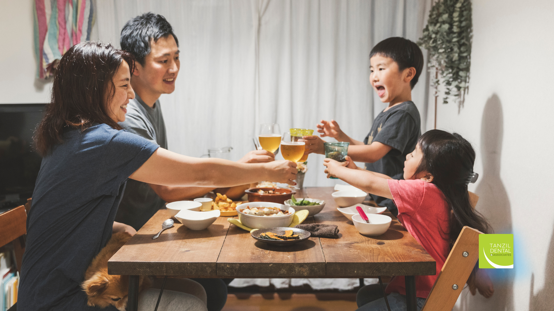 Family cheers with drinks around a wooden table in a well-lit dining room.