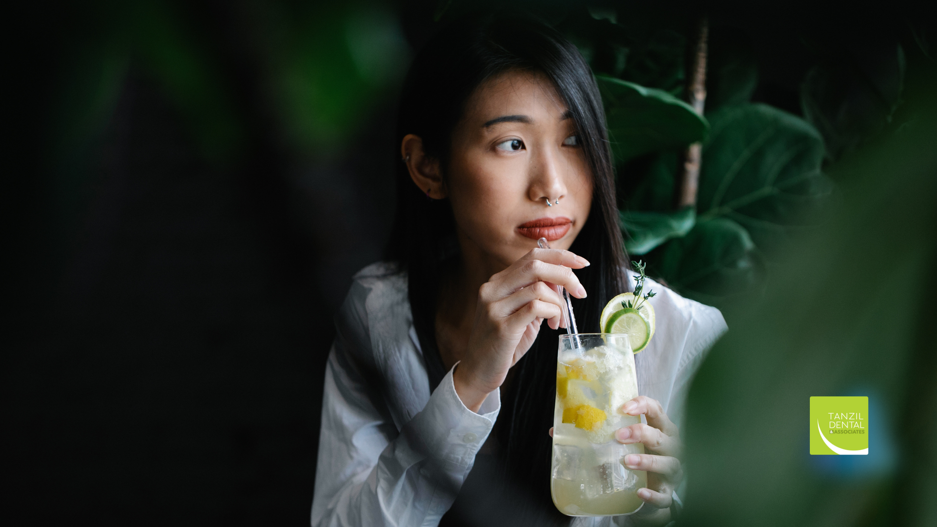 A woman is drinking a drink through a straw.