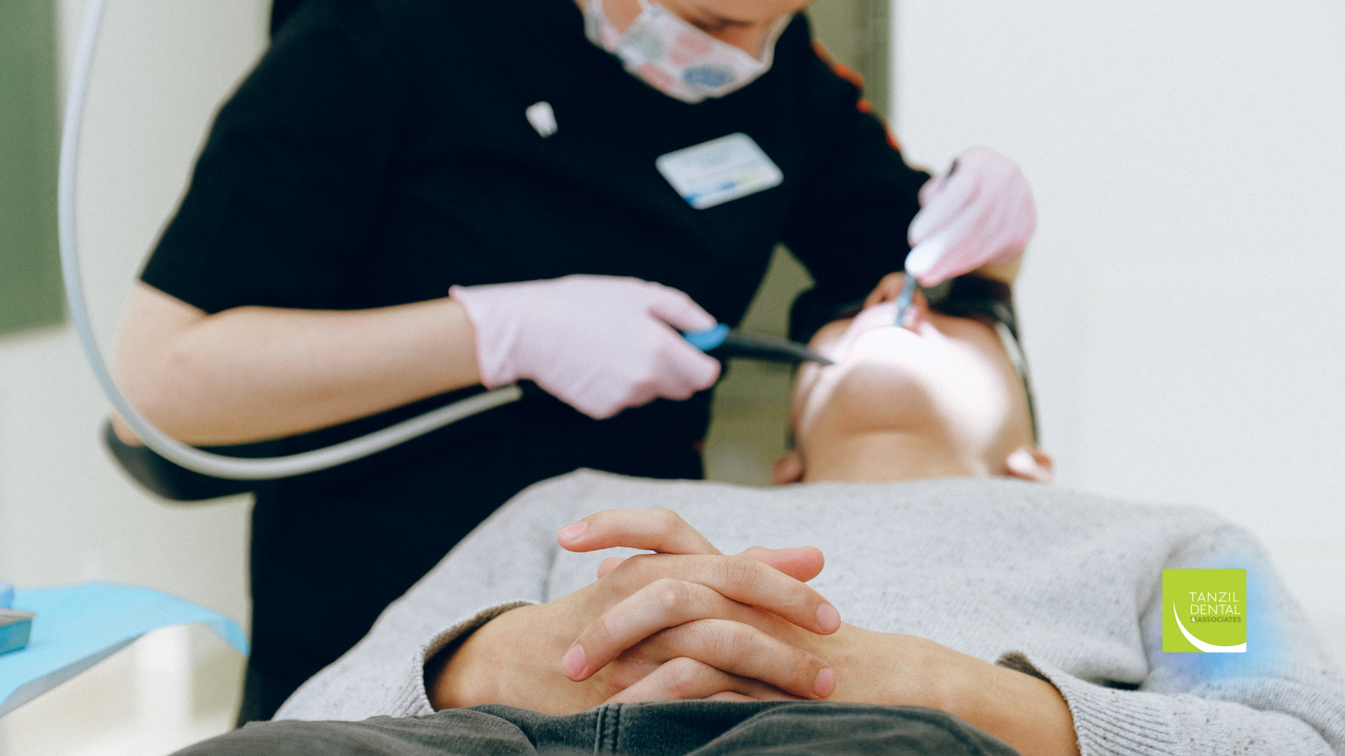A dentist is examining a patient 's teeth in a dental office.