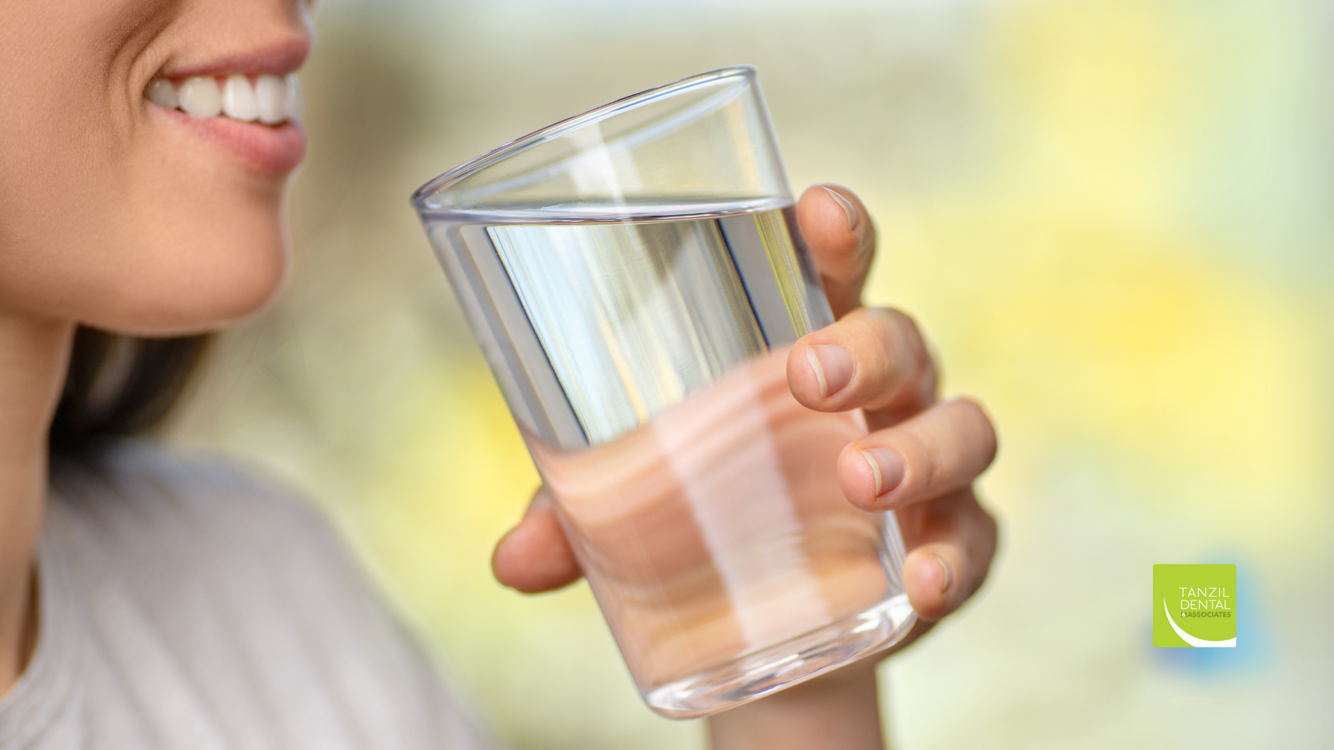 A woman is drinking a glass of water.