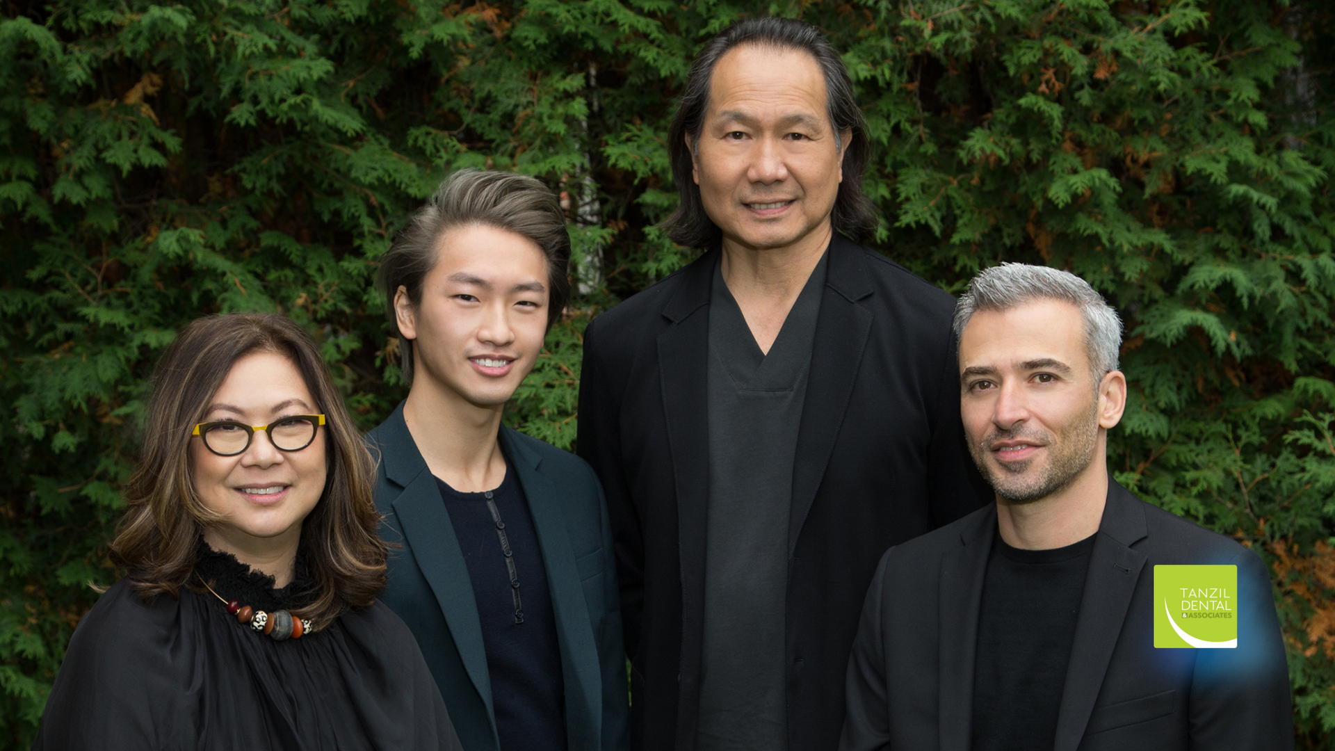 A group of people are posing for a picture in front of a tree.
