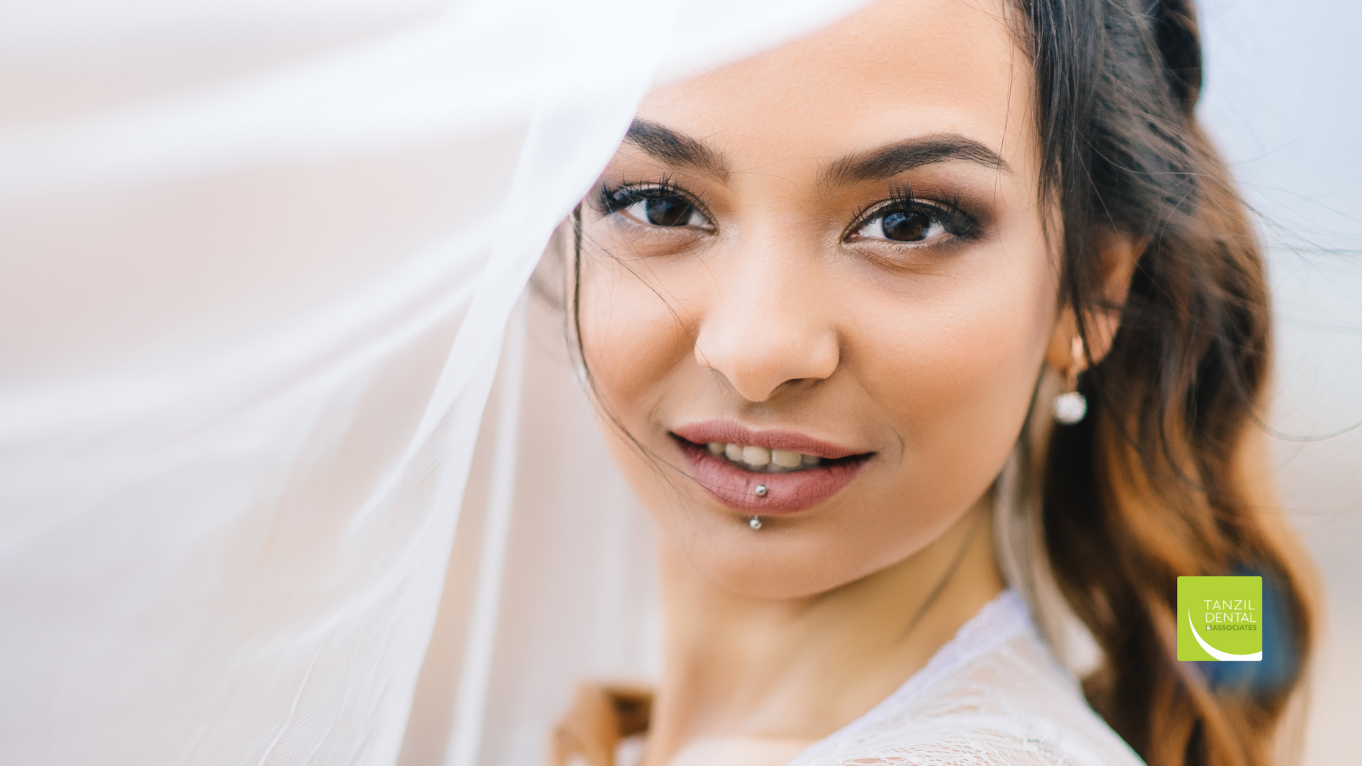 A close up of a woman covering her face with a white cloth.