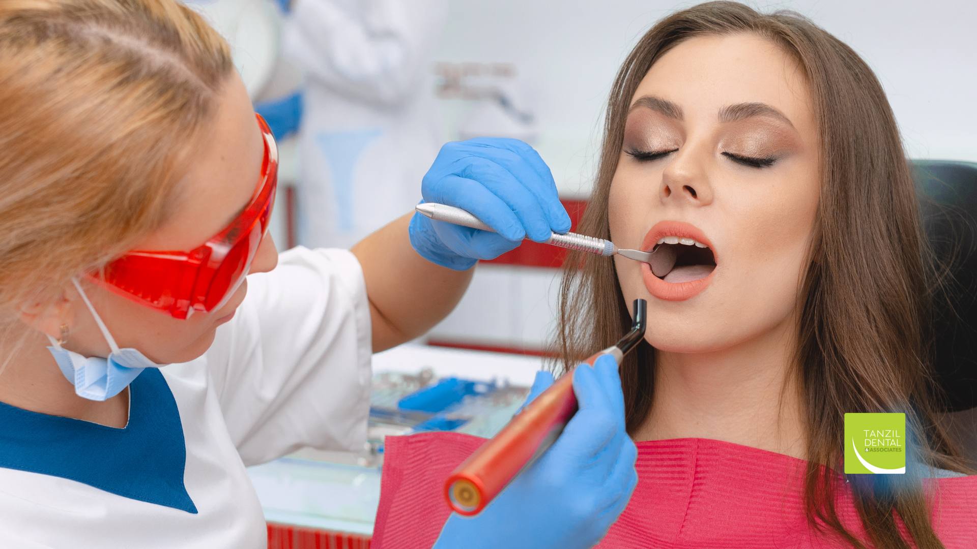 A woman is getting her teeth examined by a dentist.