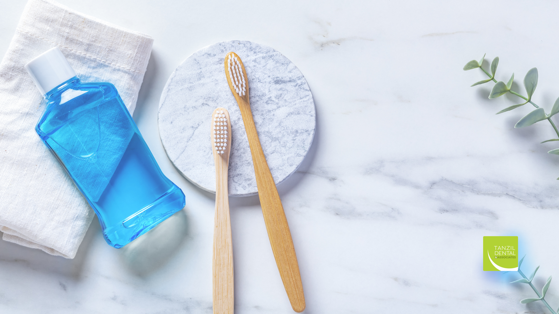 A toothbrush , mouthwash , and towel are on a marble counter.