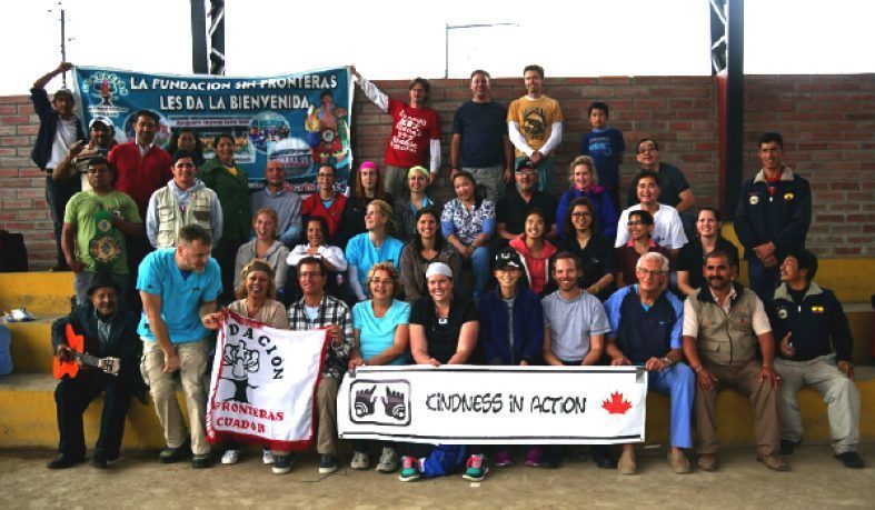 Group of people posing with banners. Indoor setting, various skin tones, many smiling.
