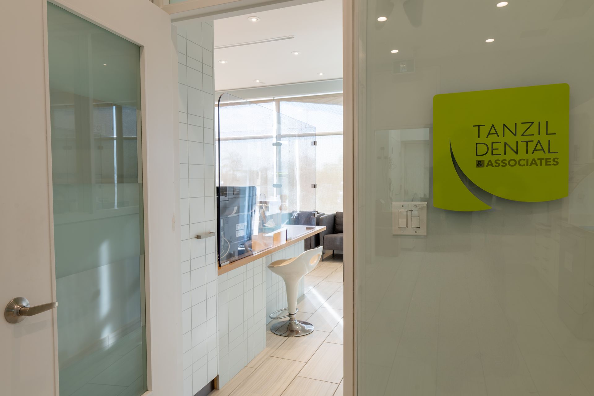 Interior view of a dental office with signage, a reception area, and waiting room.