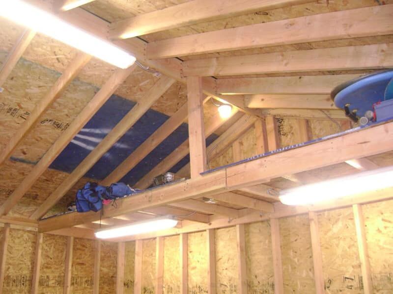 Overhead wiring and lighting during industrial electrical installation inside unfinished shed