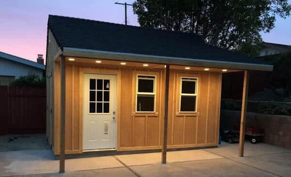 Outdoor shed with complete electrical installation and soffit lighting at dusk