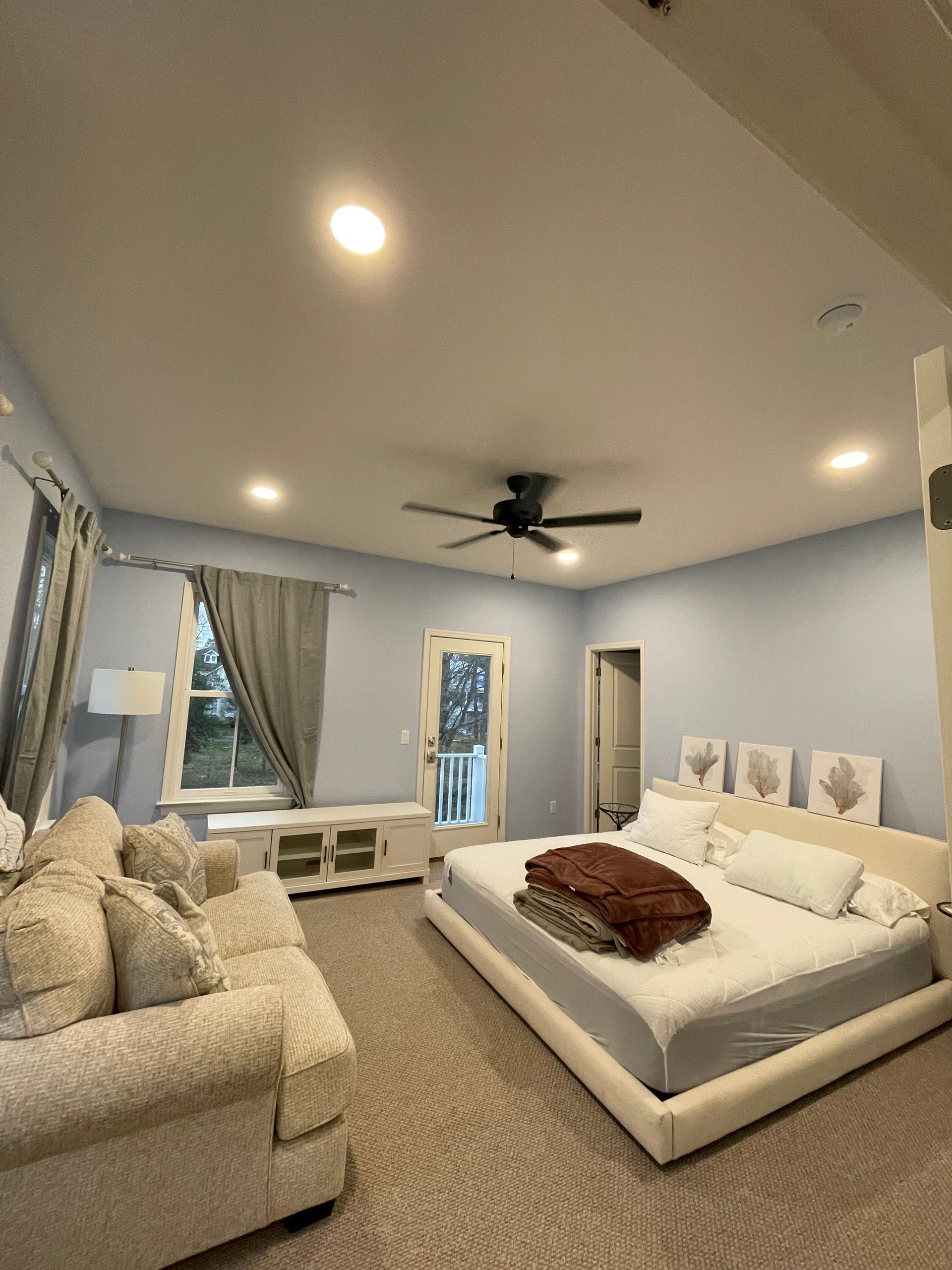 Bedroom with ceiling fan and recessed lighting installed during home electrical remodeling services