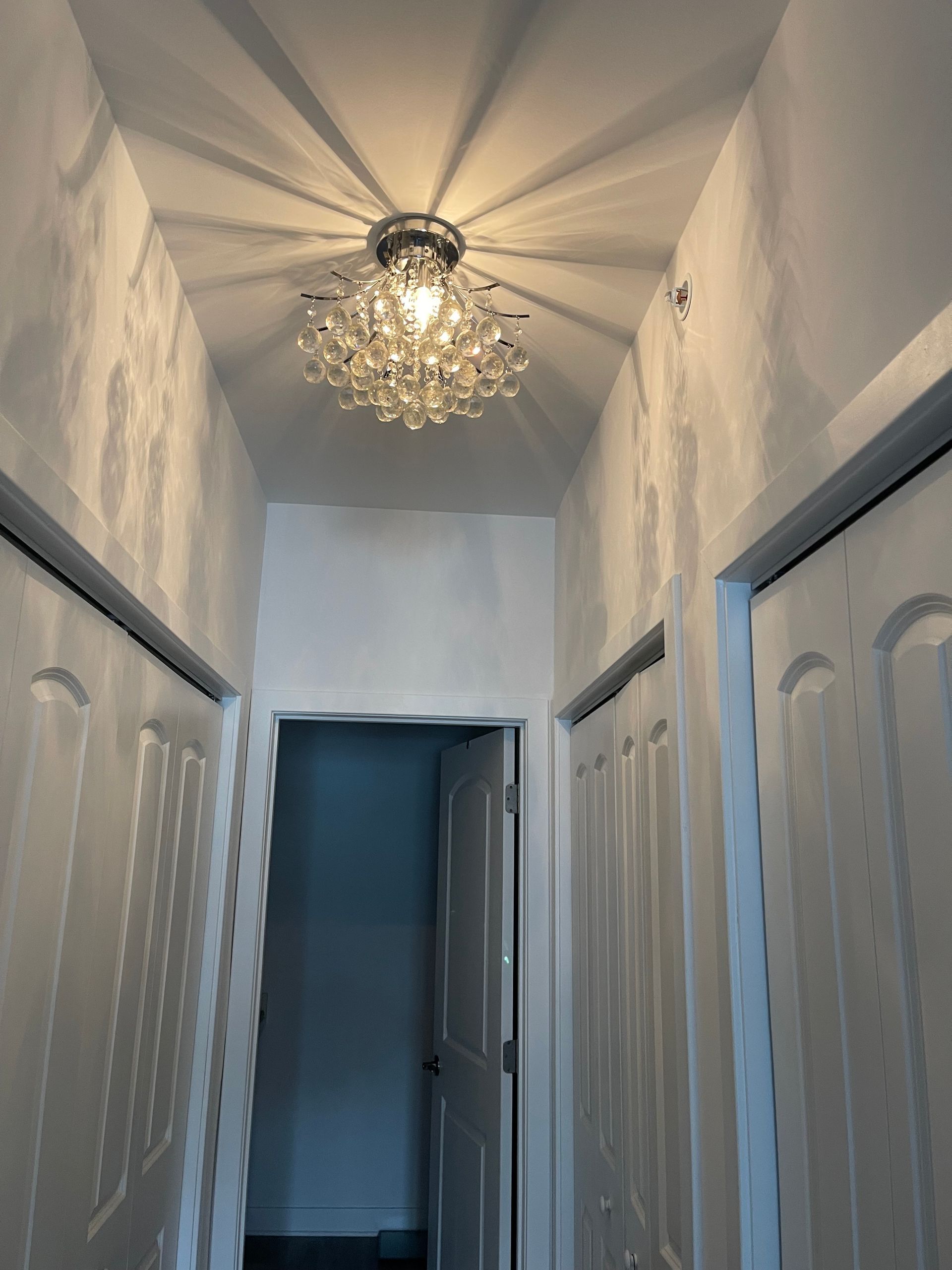 Decorative chandelier installed in hallway during home electrical remodeling services