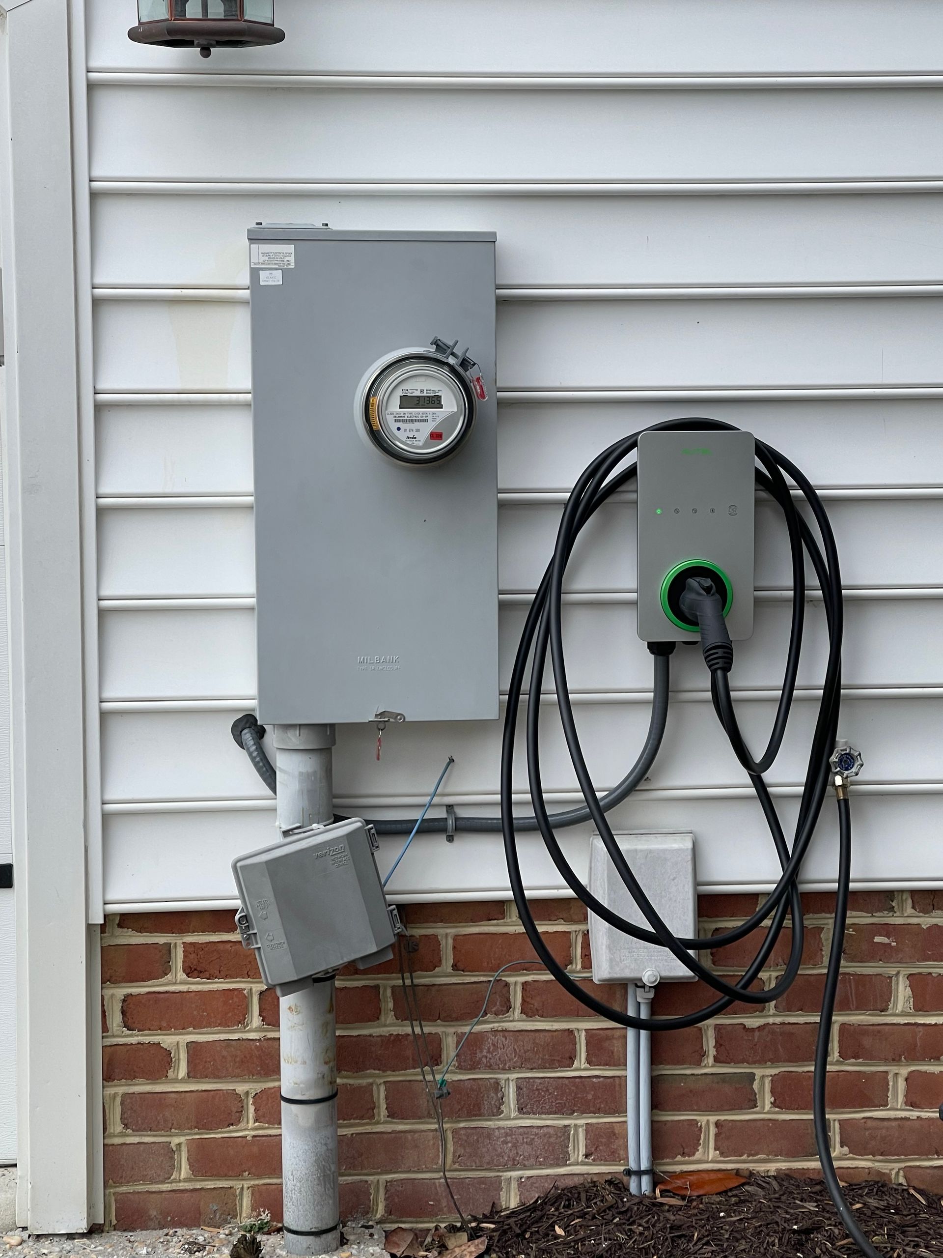 Outdoor EV charging station and utility meter setup during residential electrical installation services