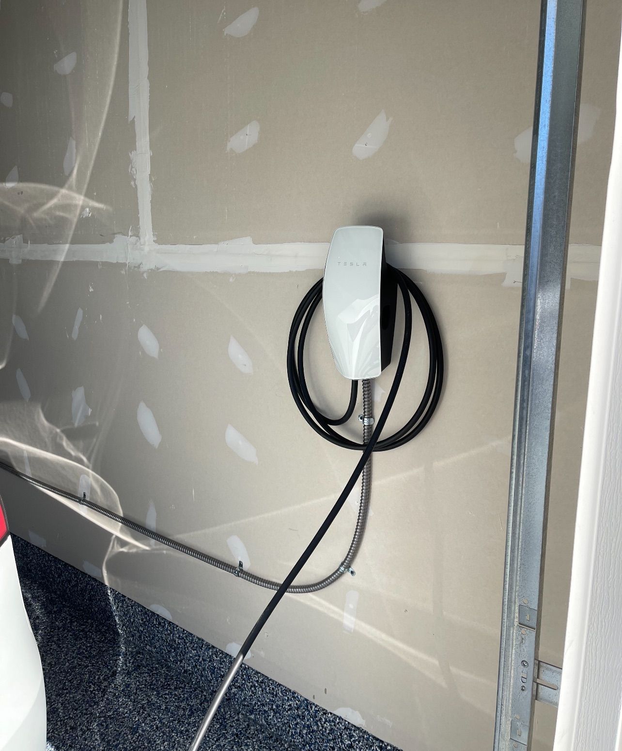 Tesla home charging station installed in garage by licensed electrician for EV electrical installation