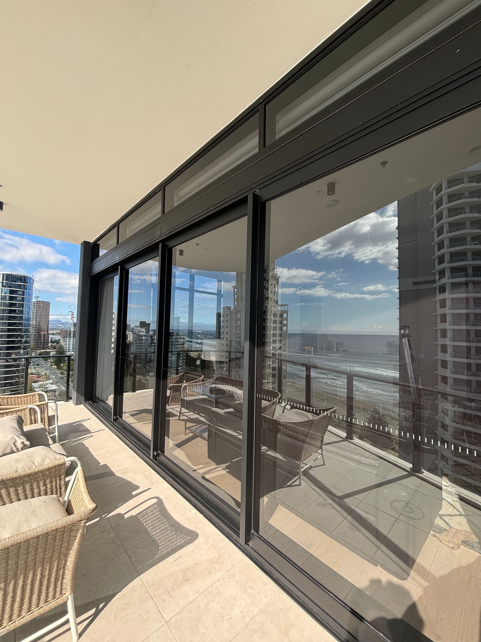 A Balcony With Full Length Glass Doors That Are Clean — Supercare Gold Coast in Miami, QLD