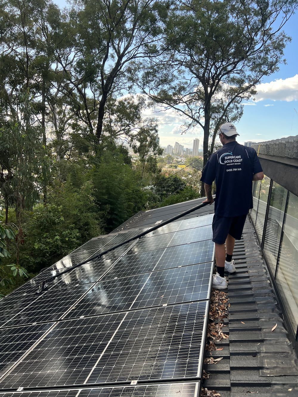 A Person Is Using A Machine To Clean A Roof And Solar Panels — Supercare Gold Coast In Burleigh Heads, QLD