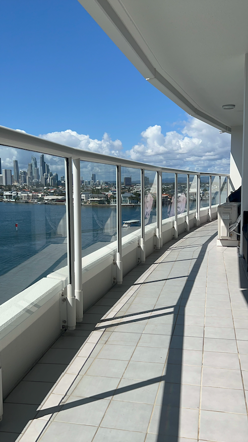 A Man Is Cleaning A Window With A Squeegee — Supercare Gold Coast in Miami, QLD