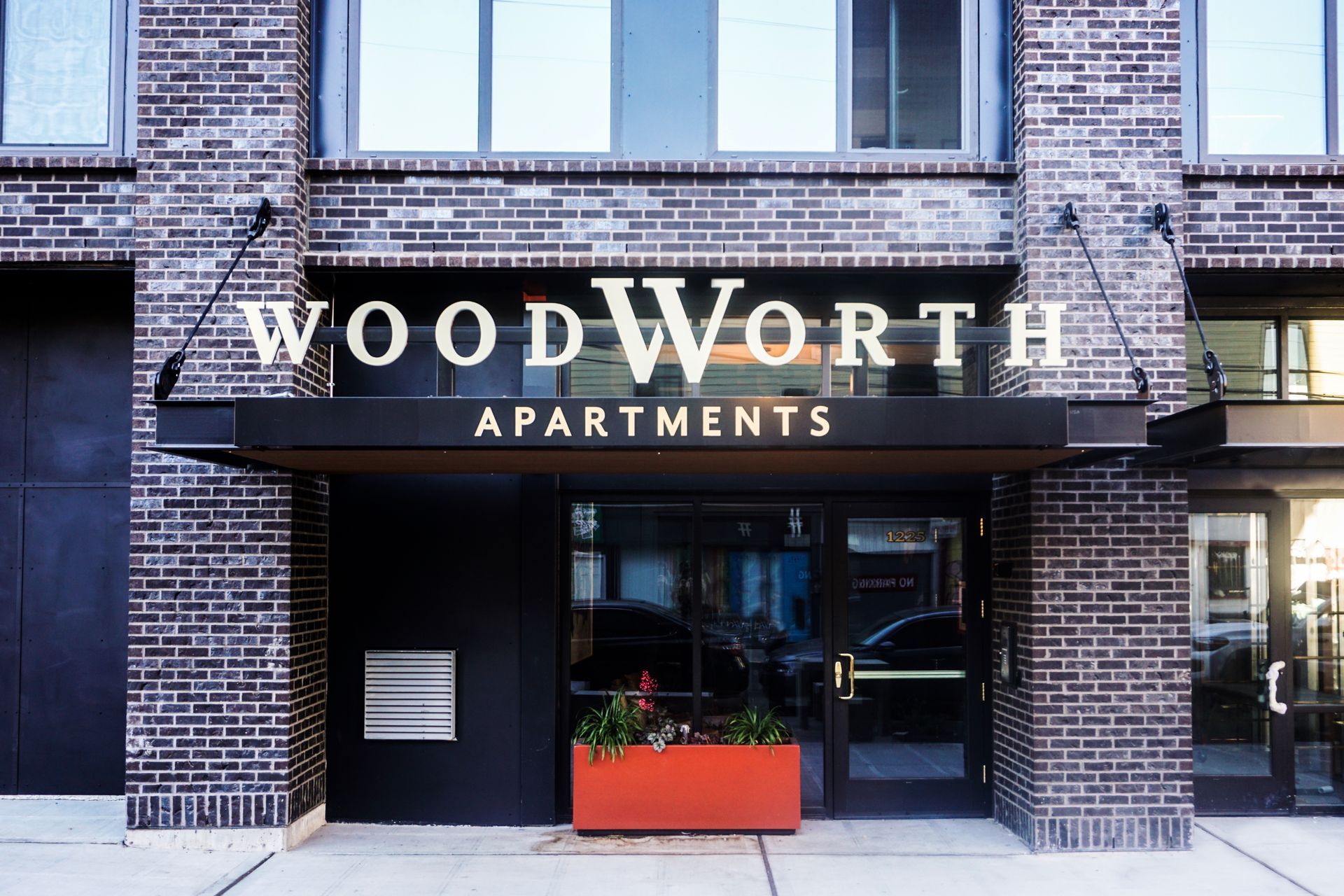 Woodworth apartments building entrance with dark brick facade and awning