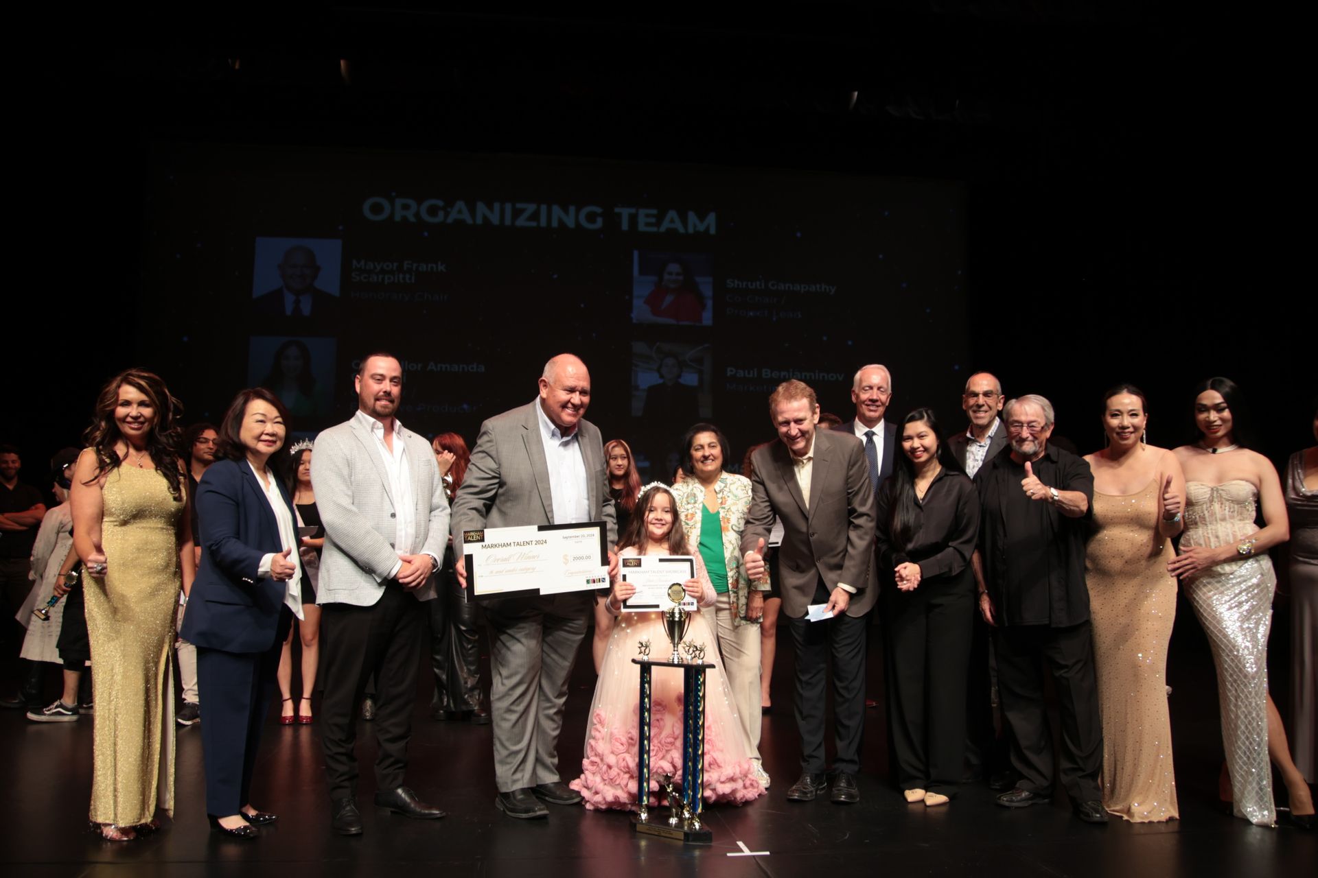 A group of people are posing for a picture on a stage.