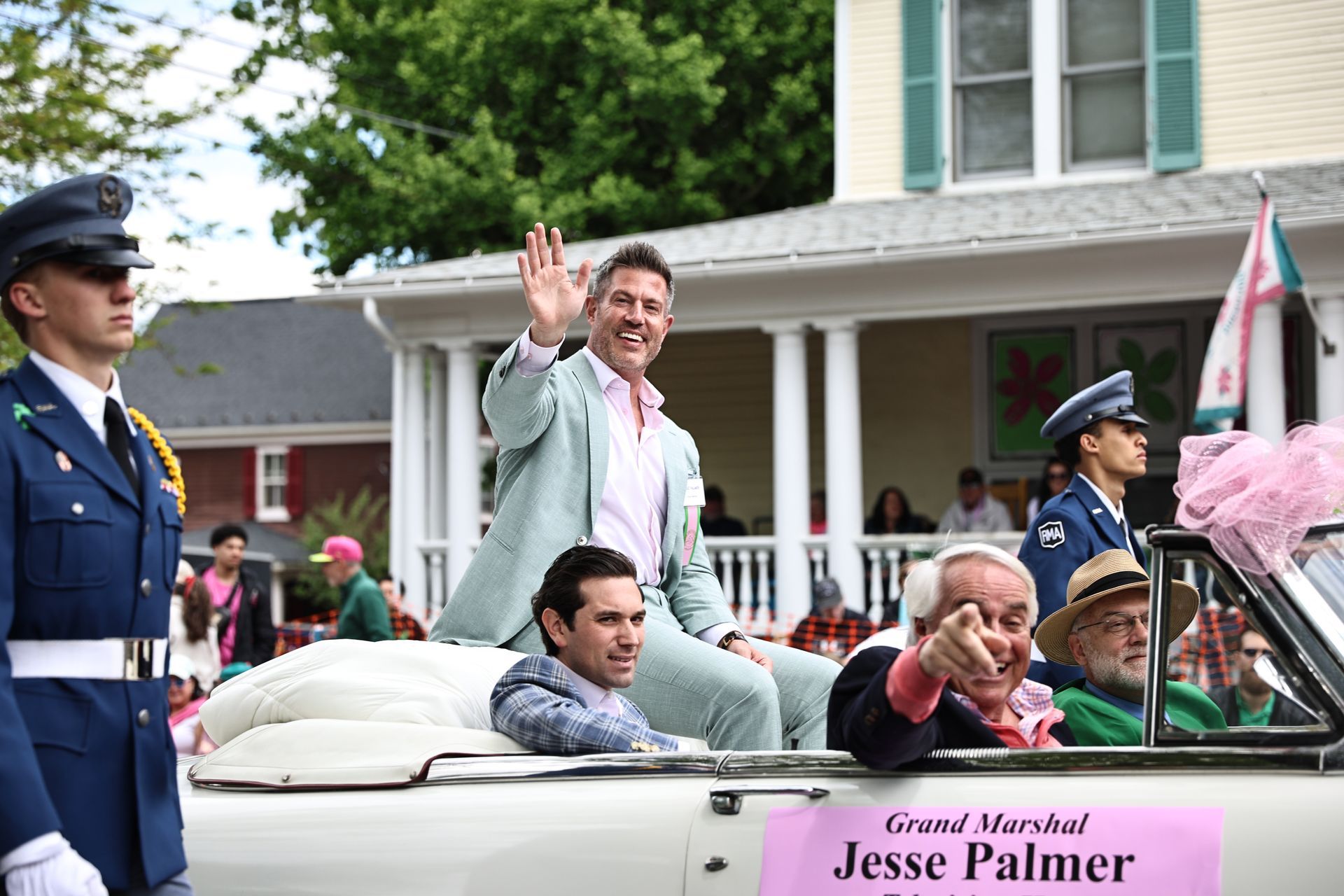 People waving from a white convertible parade float labeled “Grand Marshal Jesse Palmer”