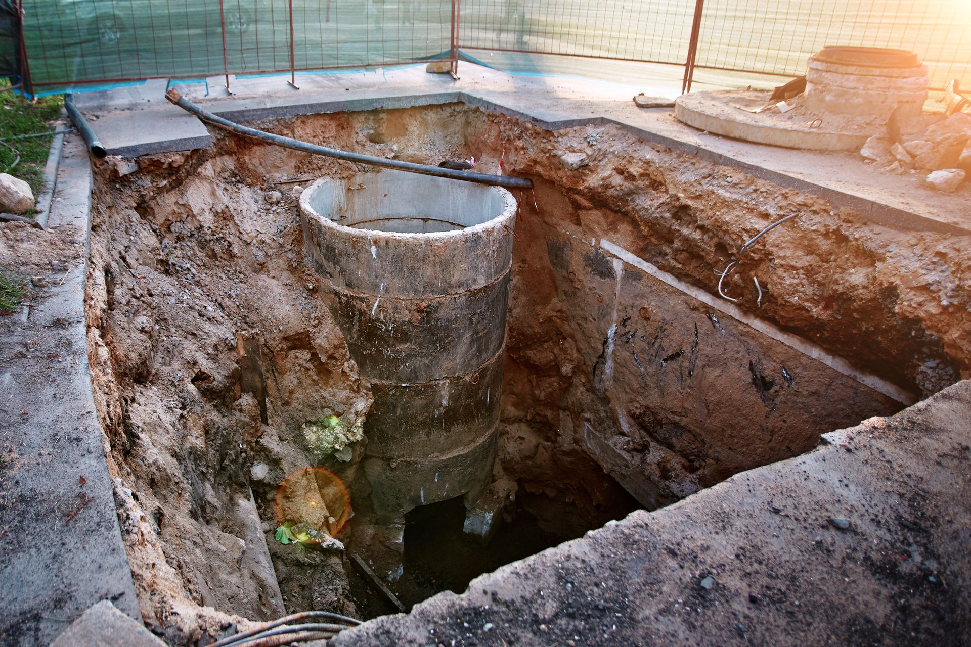 A manhole cover is being installed in a hole in the ground.