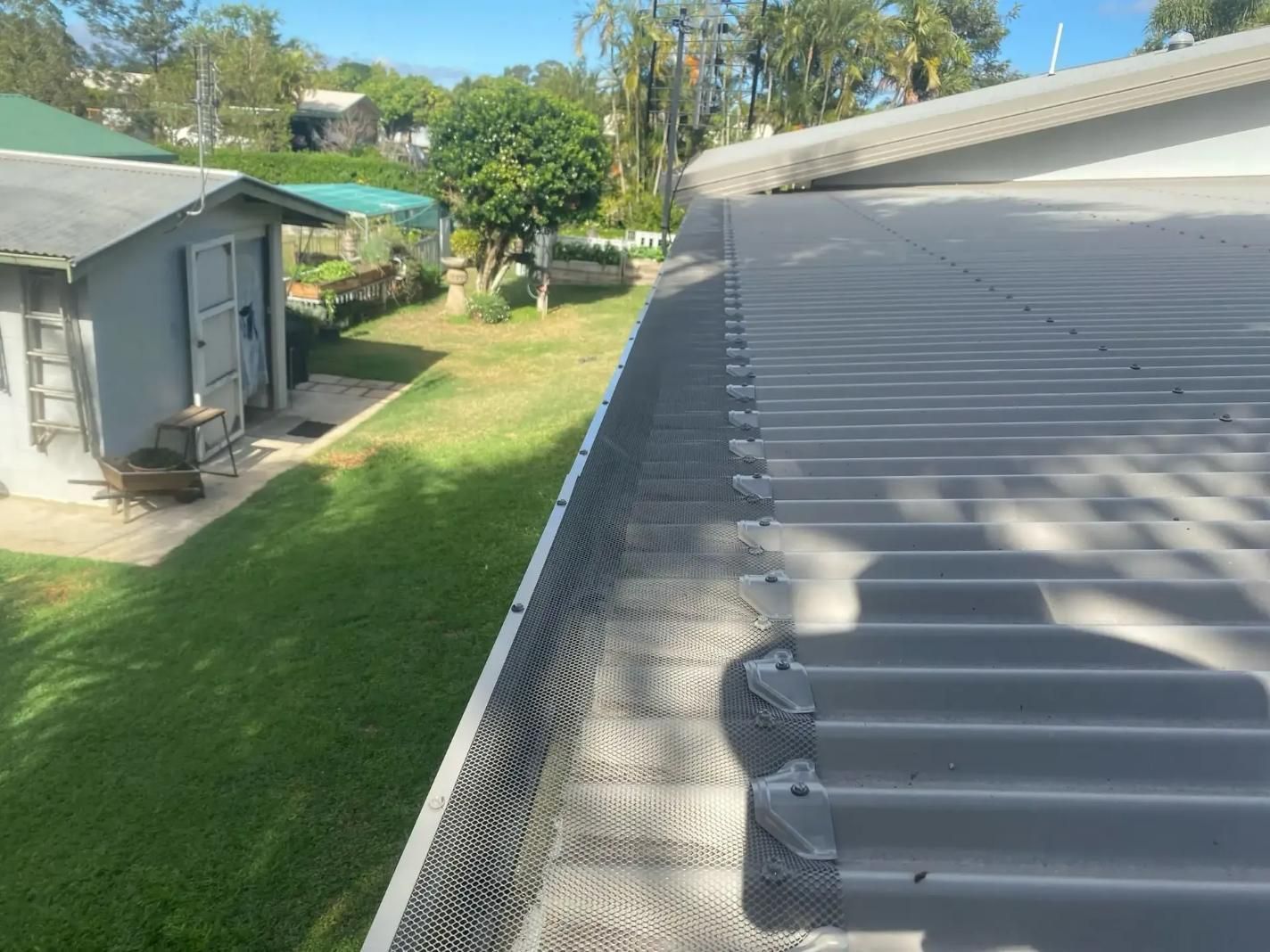 A Gutter on The Roof of A House with A Shed in The Background — All-Clear Gutter Guard NQ in Cairns, QLD