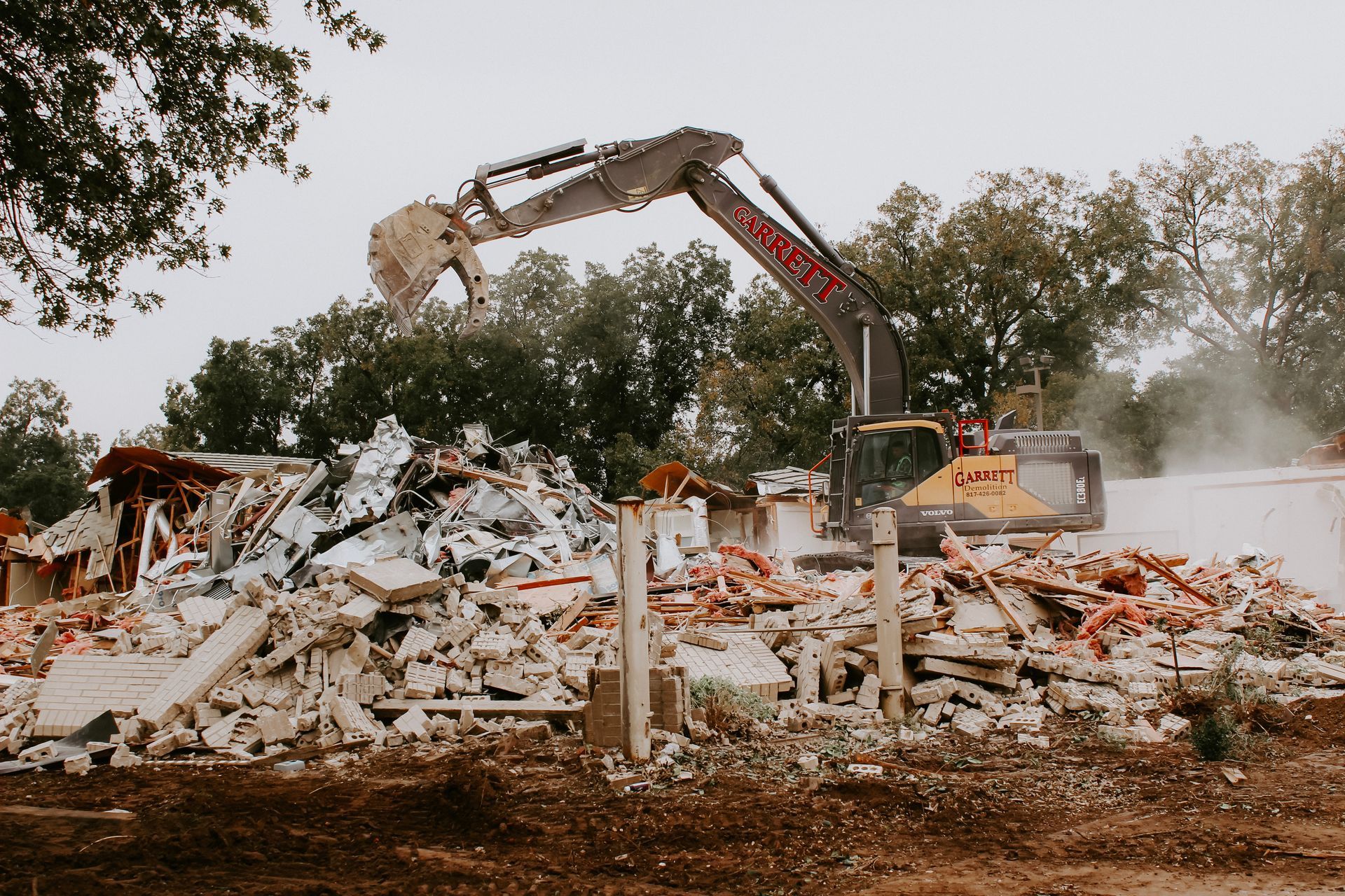 A large excavator is demolishing a building.