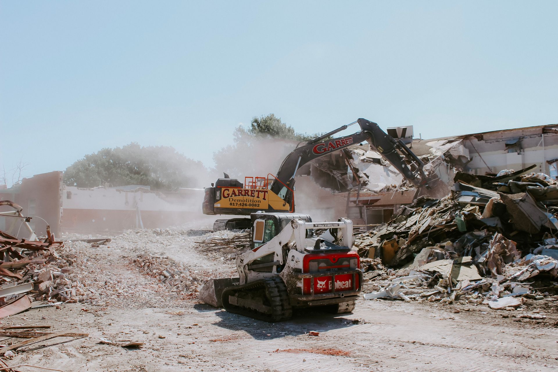 A bulldozer is demolishing a building on a construction site.