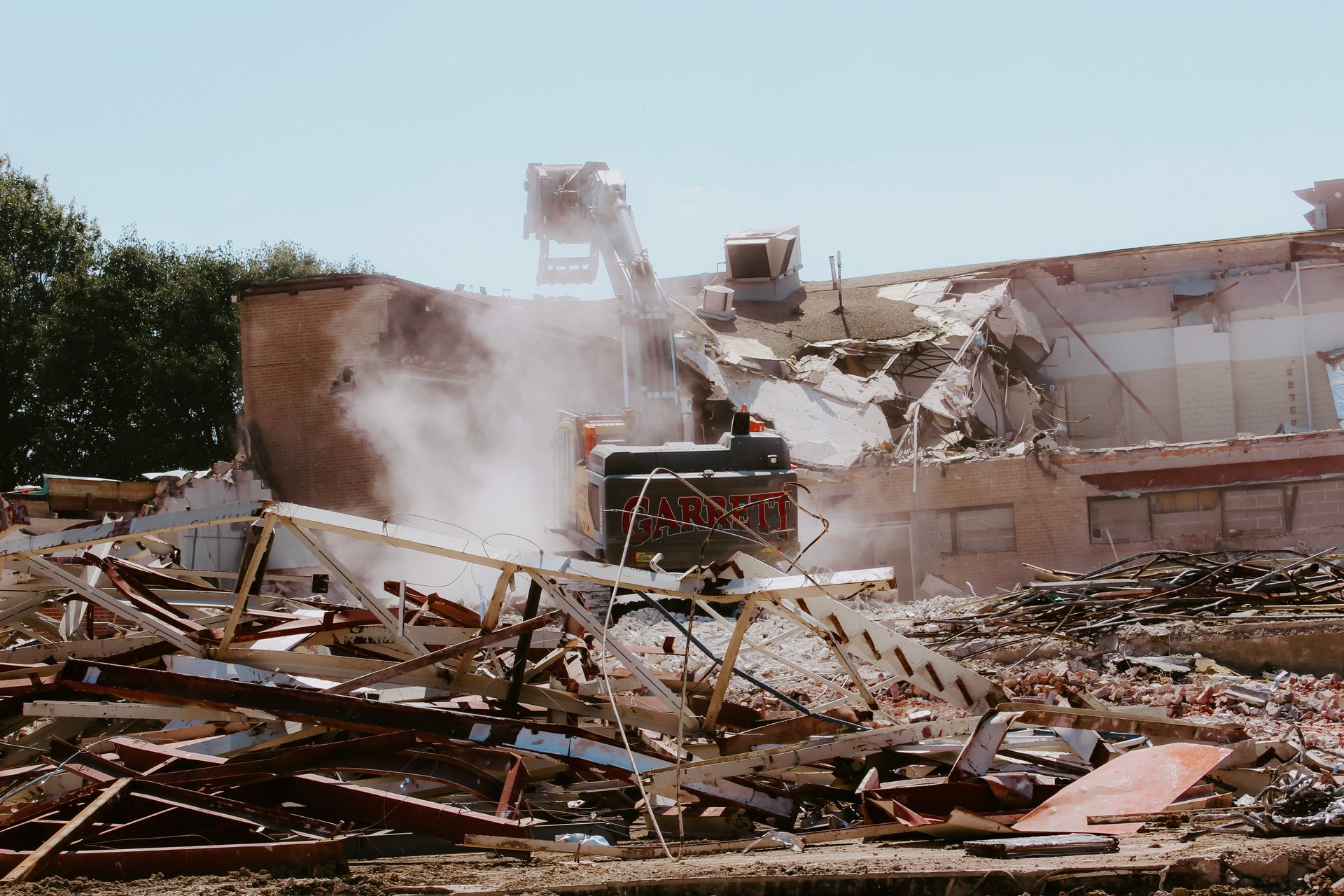 A large building is being demolished with smoke coming out of it