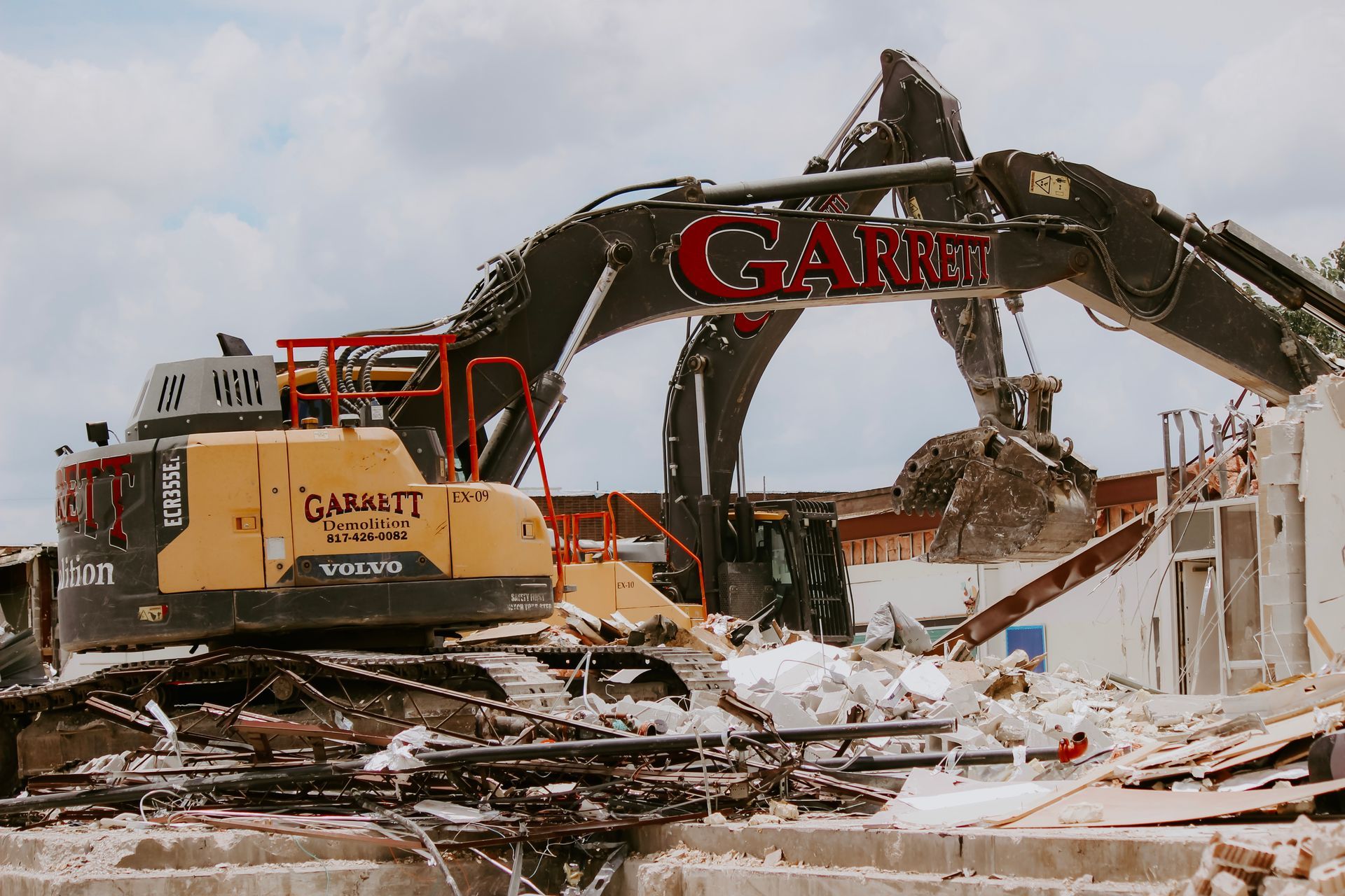 A large excavator is demolishing a building.