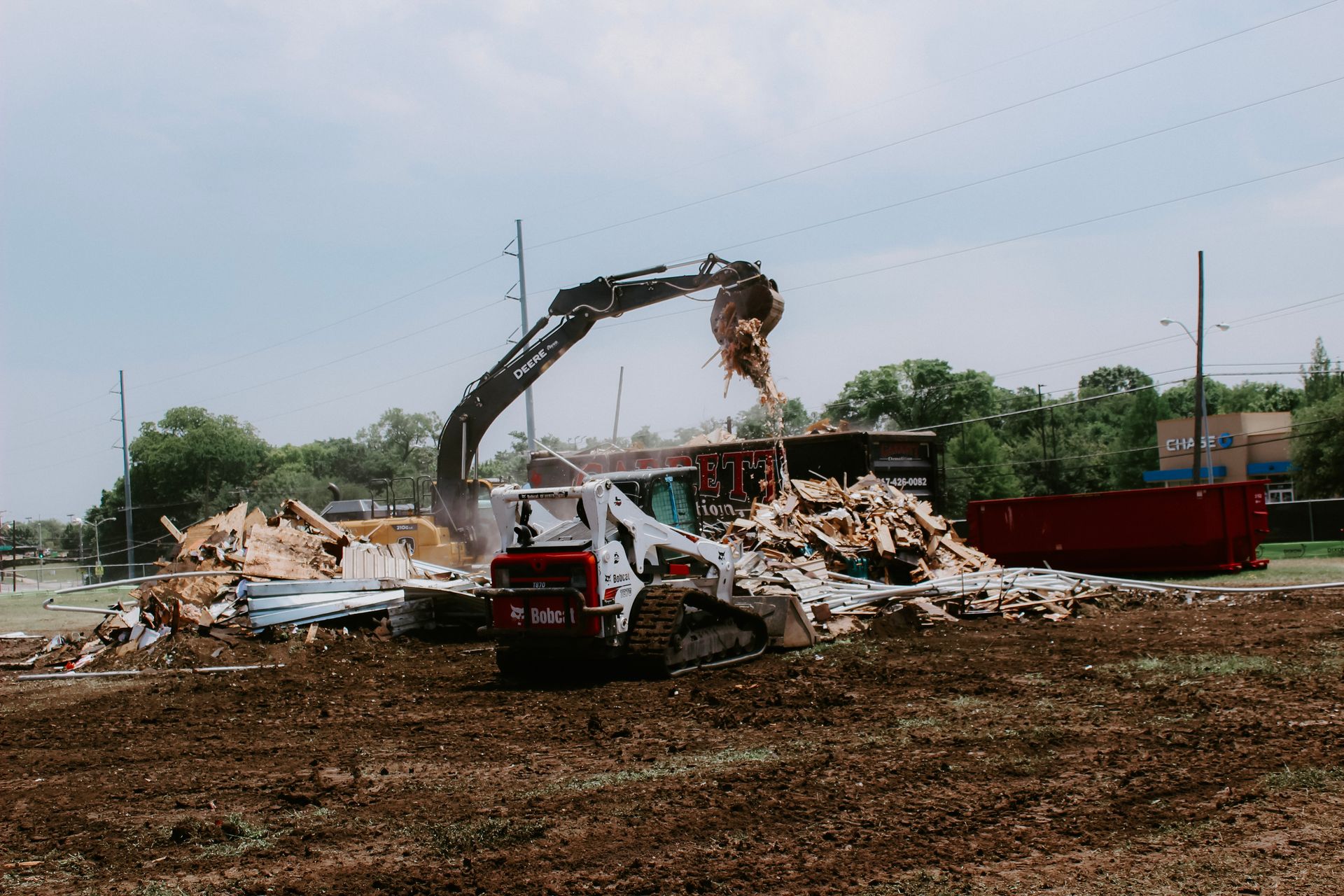 A bulldozer is demolishing a building in a field.