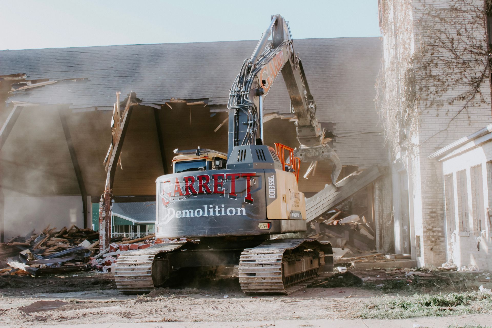 A large excavator is demolishing a building.