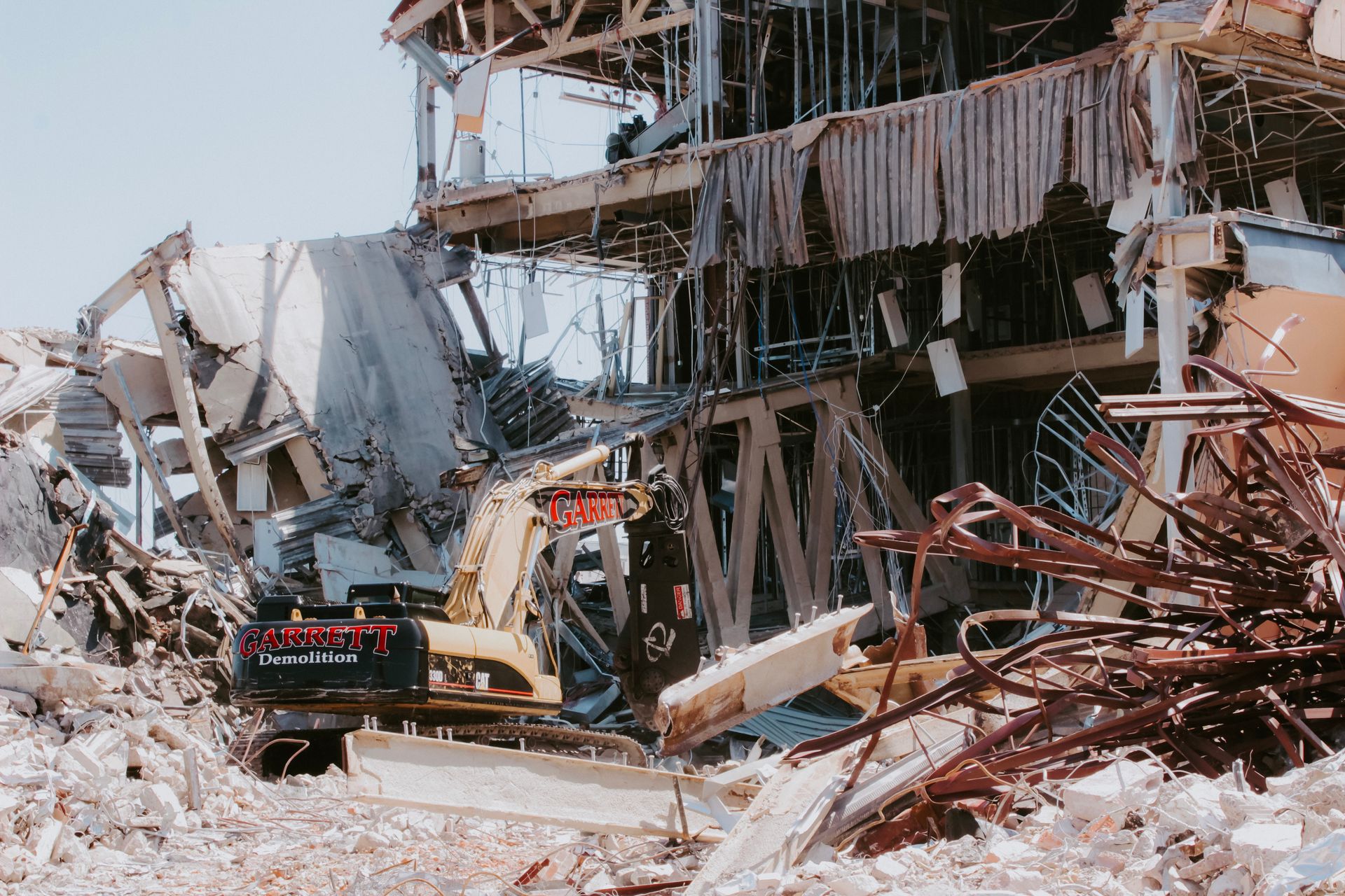 A large building is being demolished by a bulldozer.