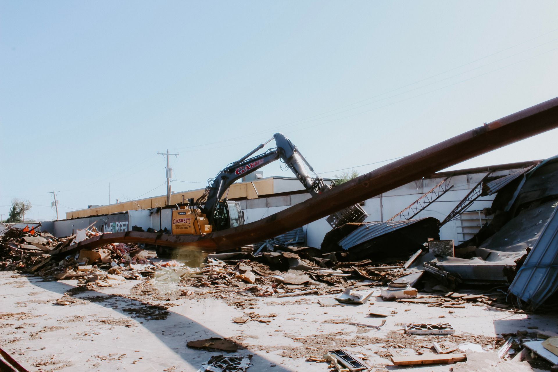 A large building is being demolished with a large excavator.