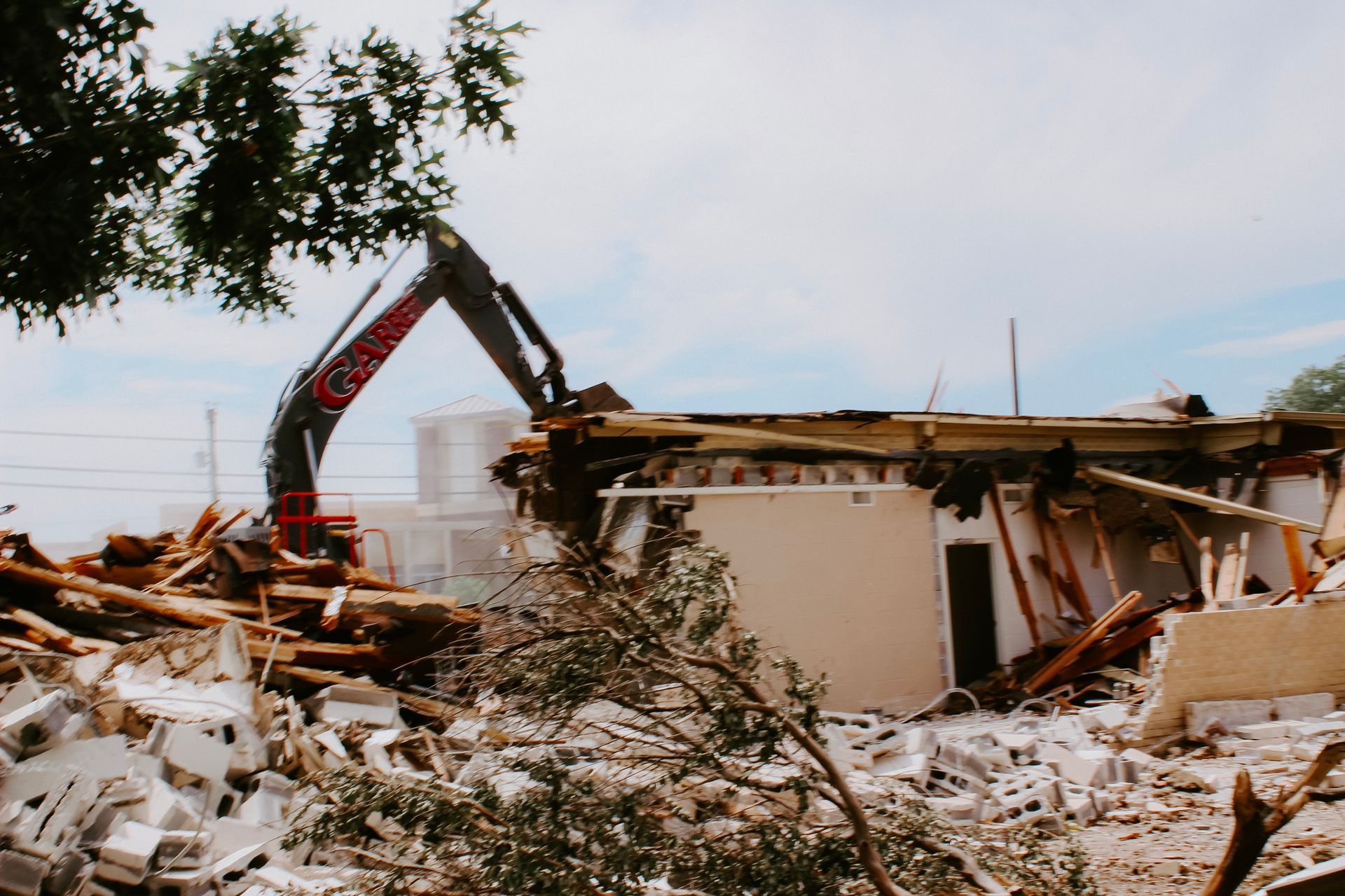 A large building is being demolished by a crane.