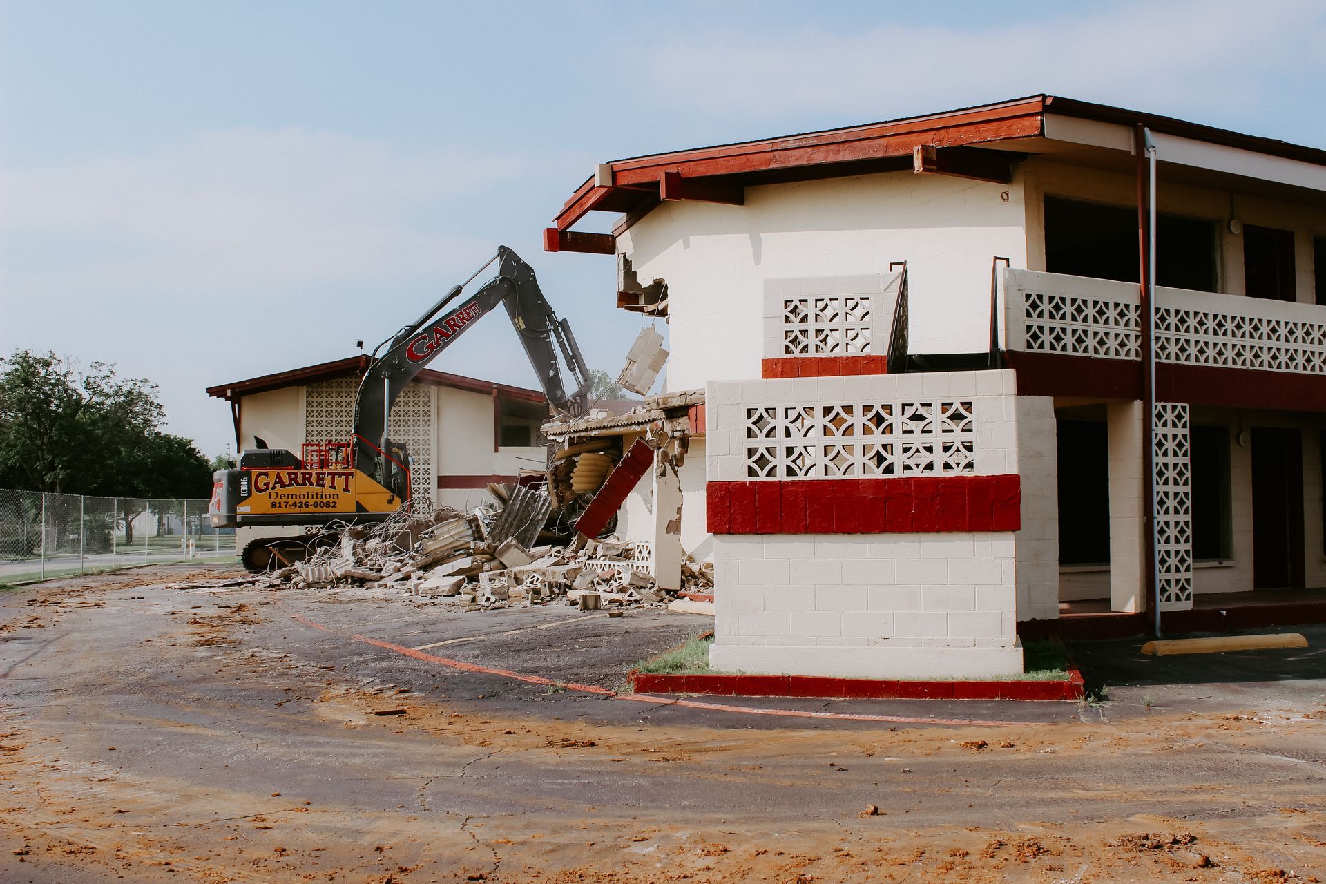a building is being demolished with a bulldozer in the background