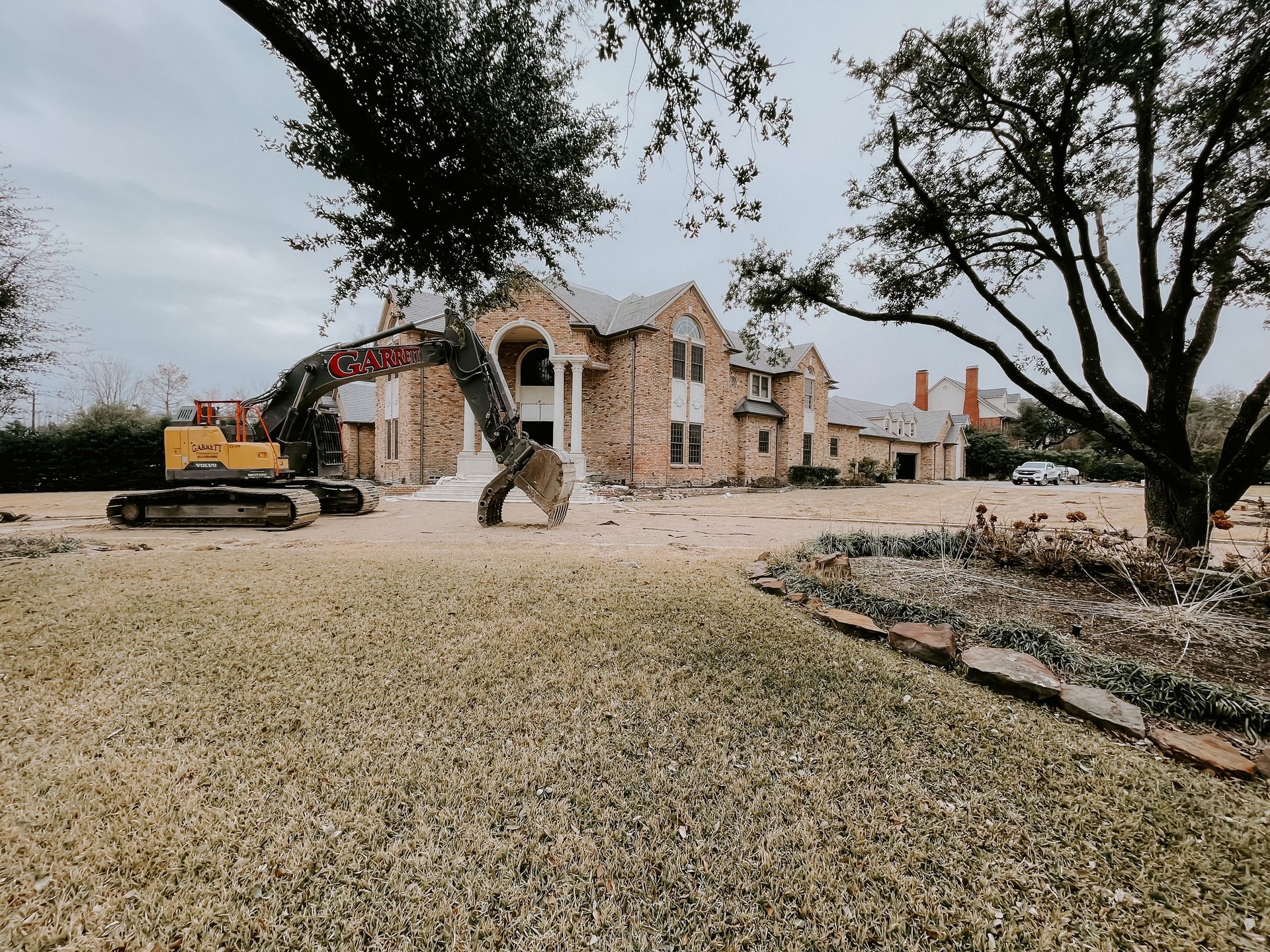 A large house is being demolished by a bulldozer.
