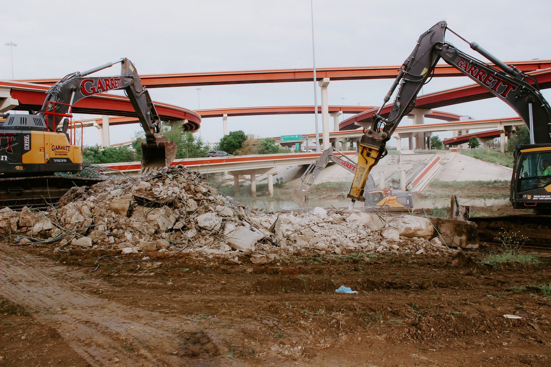 A couple of excavators are working on a construction site.