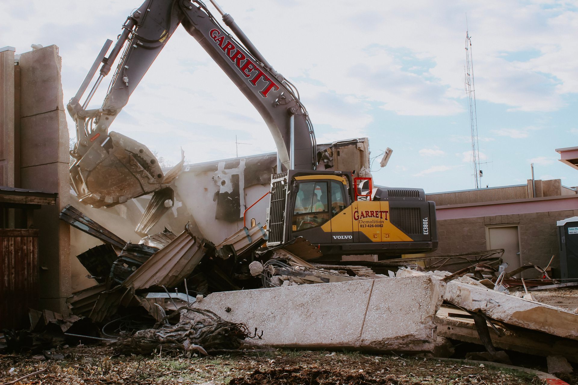 A large excavator is demolishing a building.