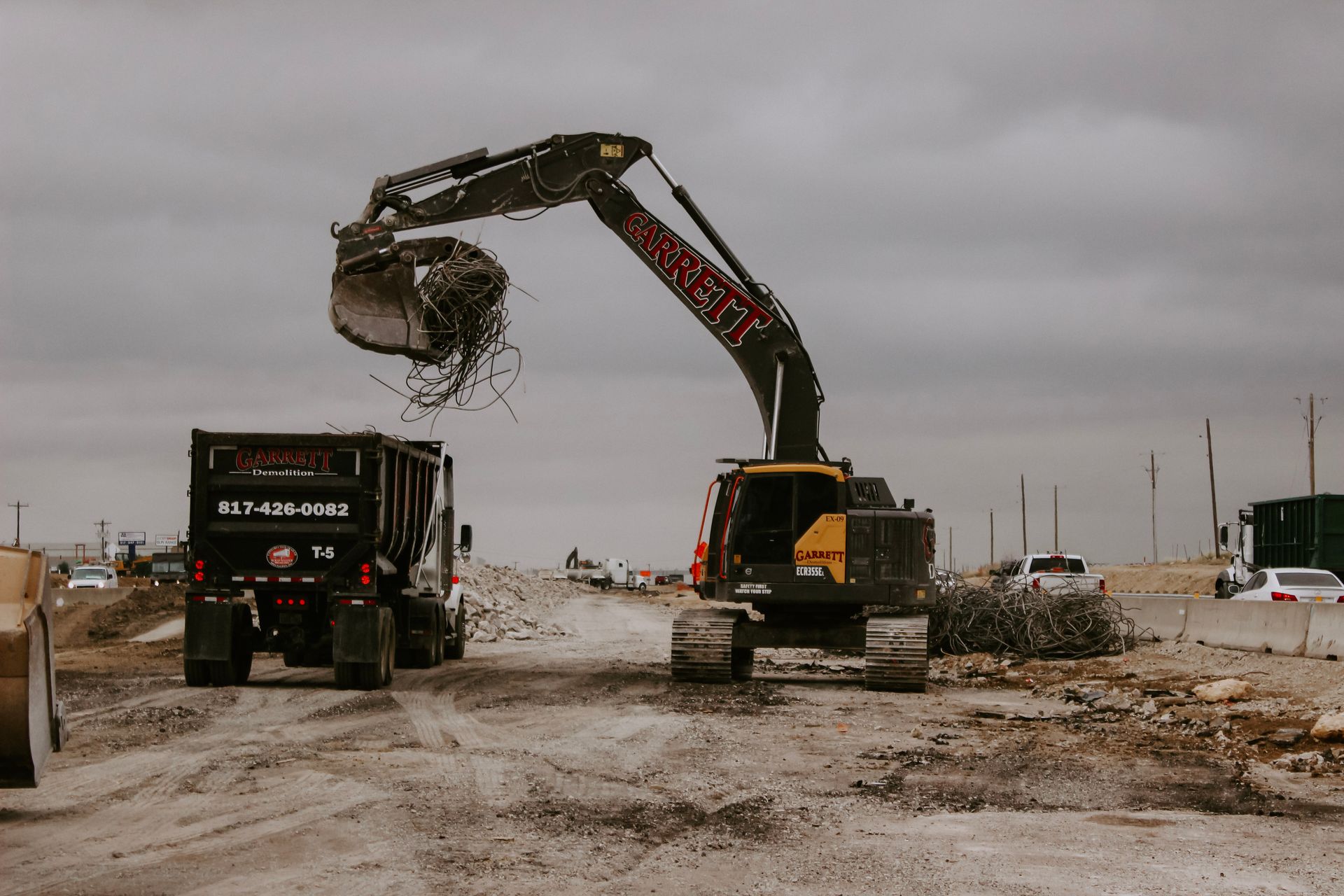 a bulldozer is loading dirt into a dump truck at a construction site .