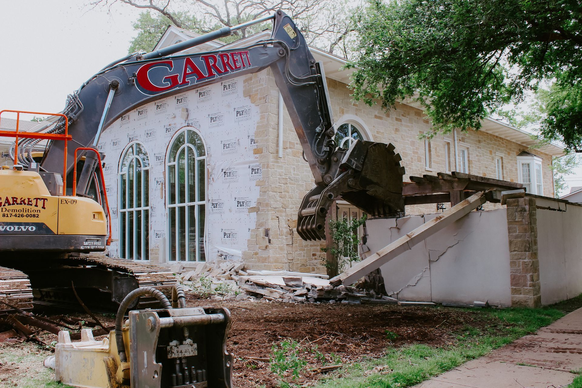 A large excavator is demolishing a house.