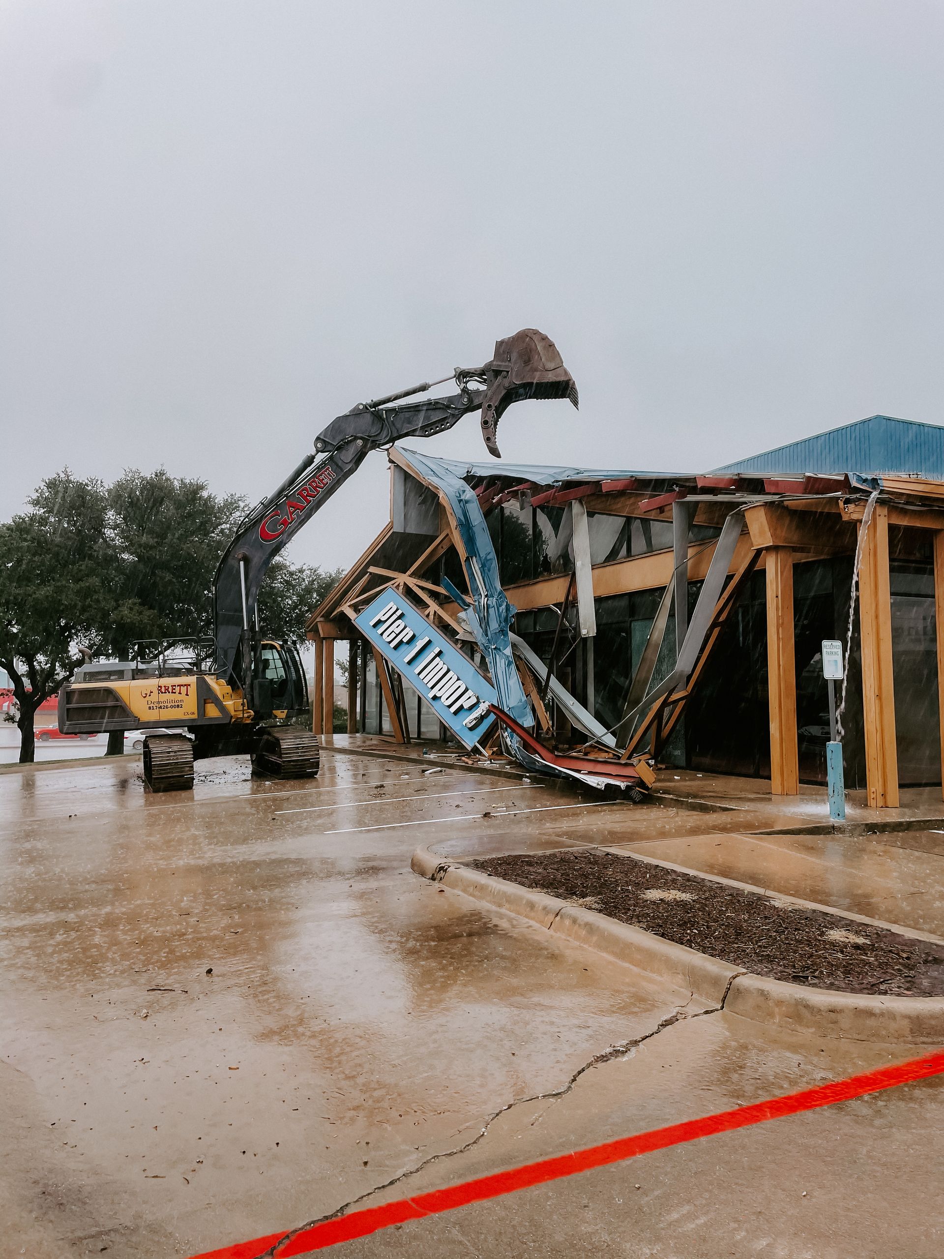 A large building is being demolished by a bulldozer.