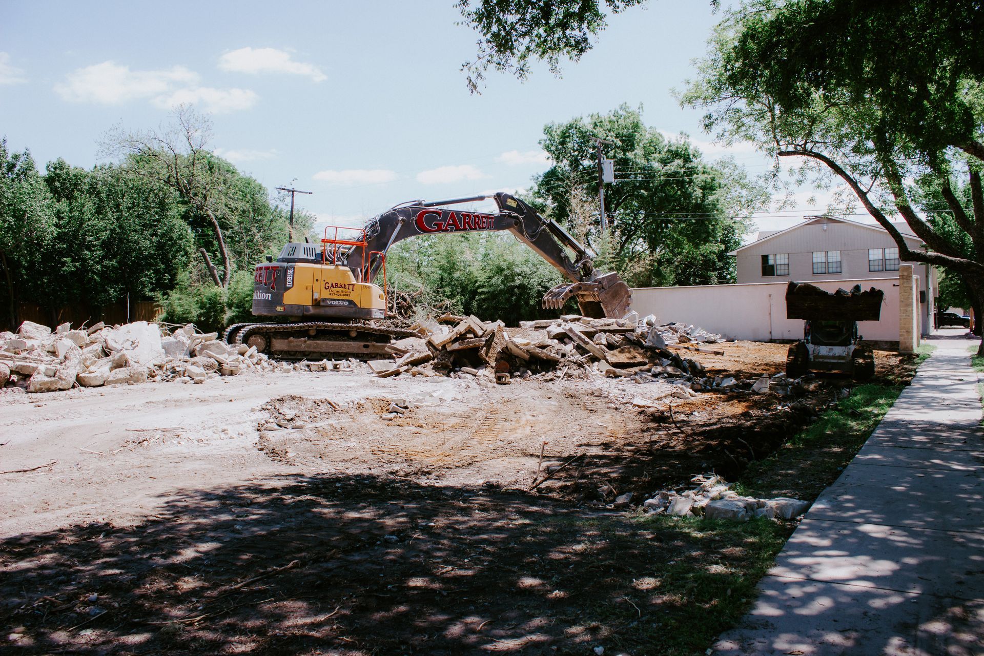 A bulldozer is demolishing a building in a residential area.