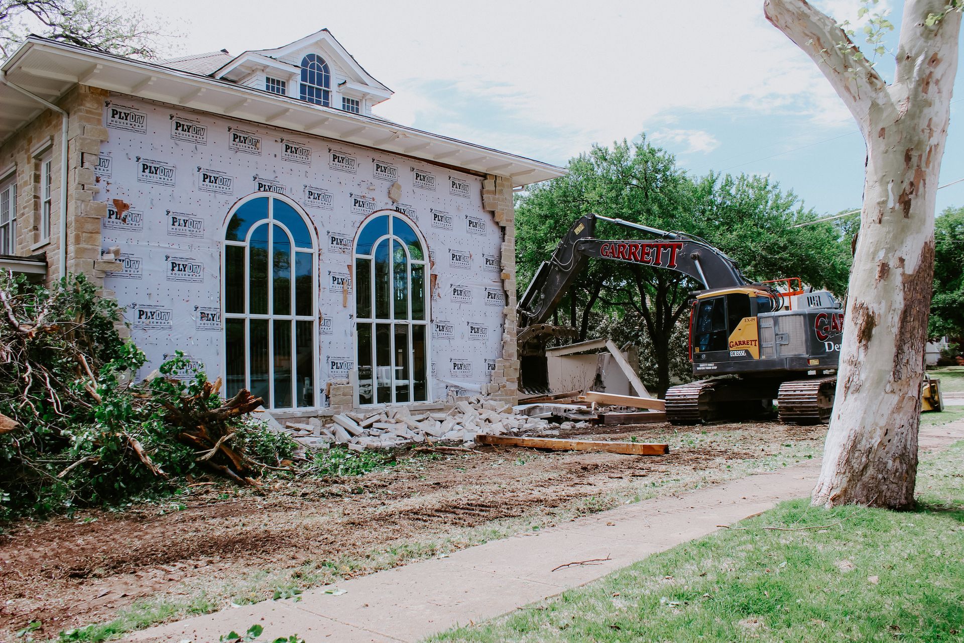 A house is being demolished by a bulldozer.