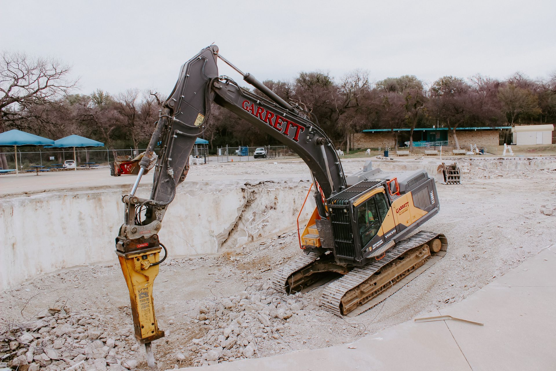 A large excavator is sitting on top of a dirt field.