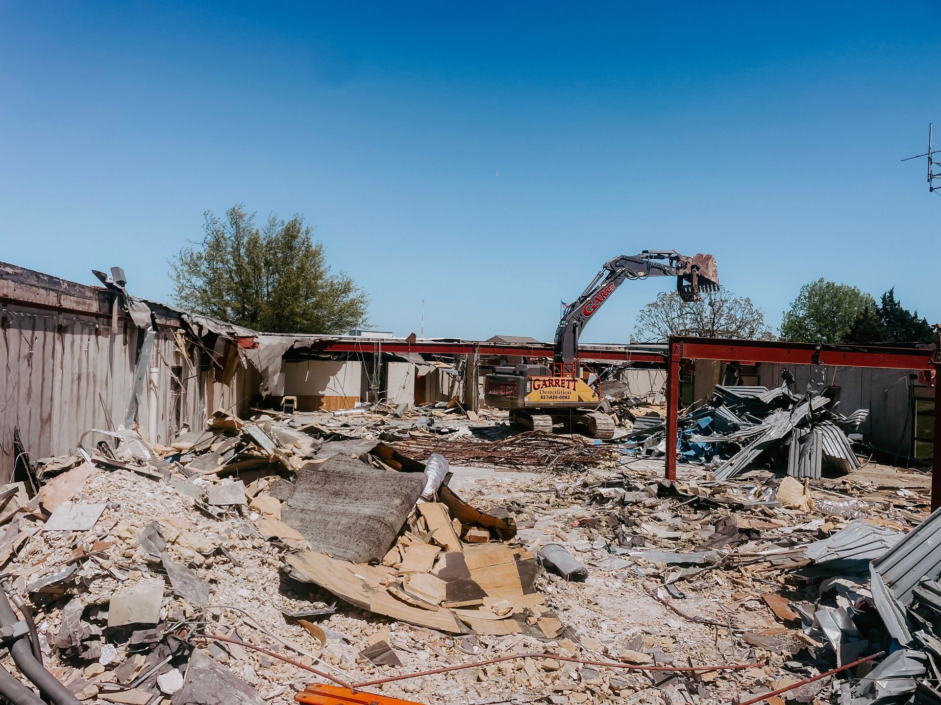 A large building is being demolished by a bulldozer.