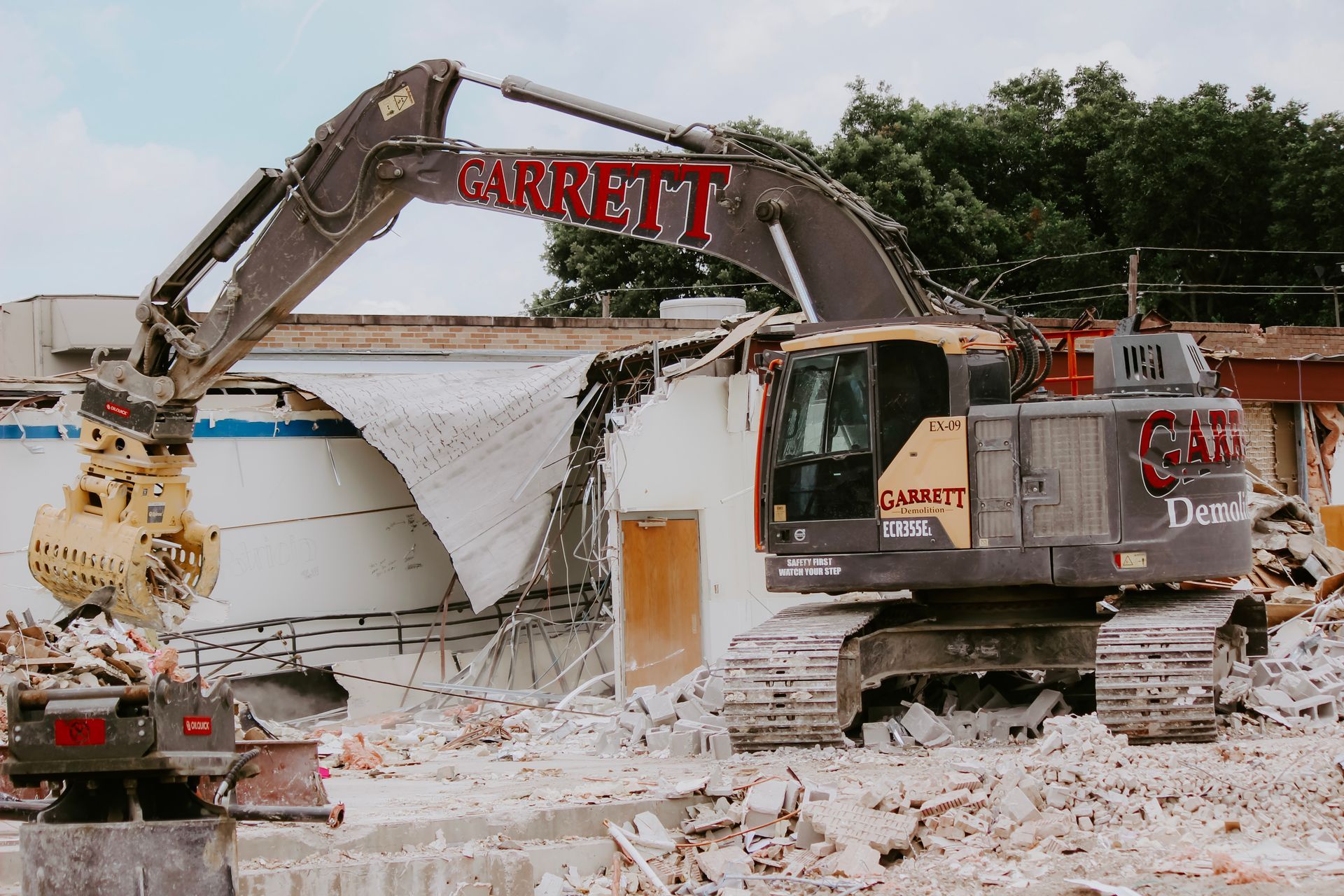 A large excavator is demolishing a building.
