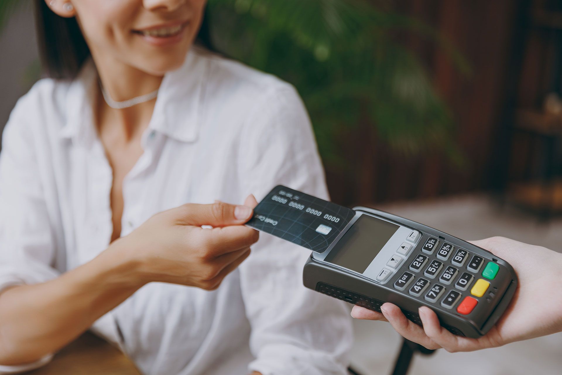 A woman is paying with a credit card at a restaurant.