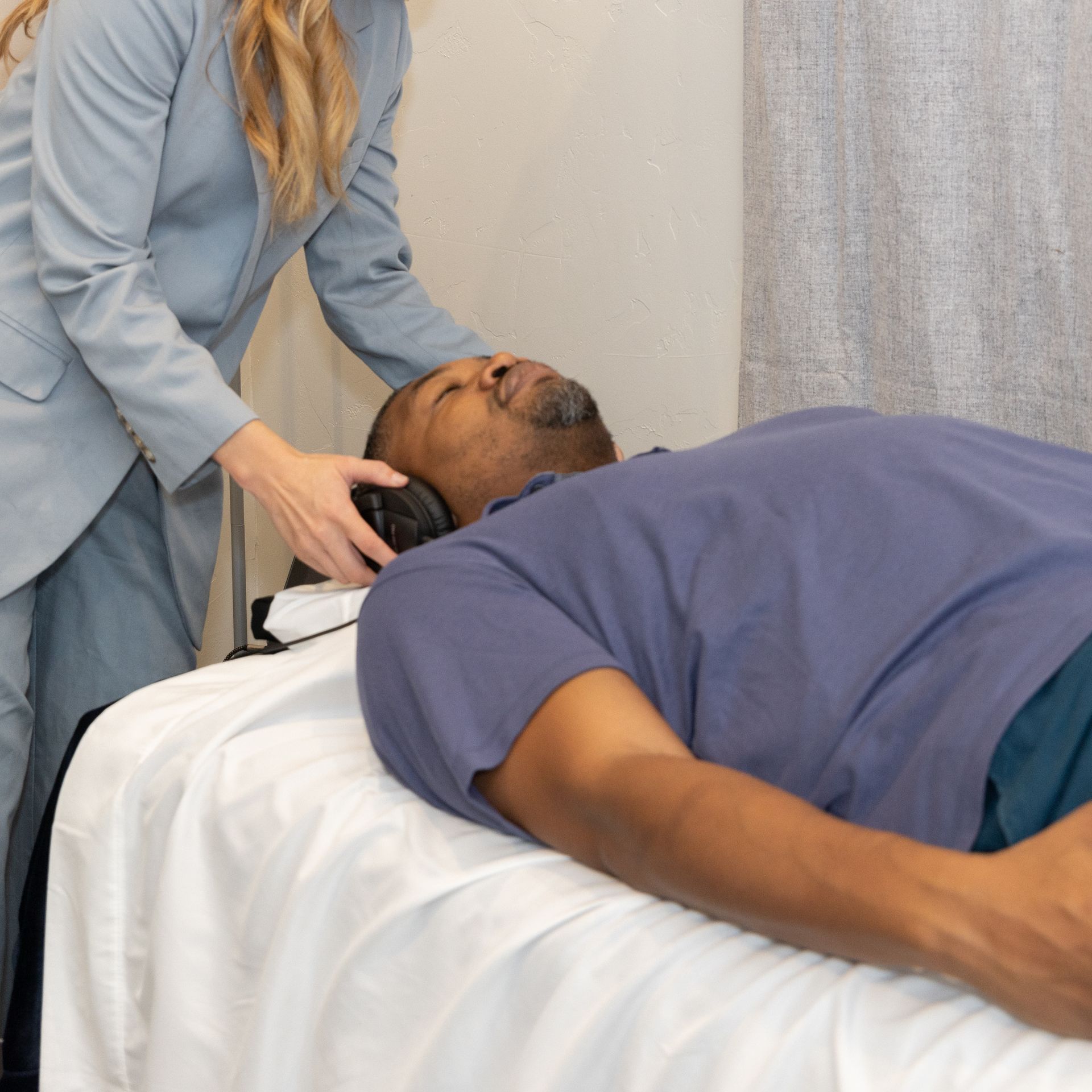 A man lying on vibroacoustic sound bed listening to solfeggio frequencies from a sound healing therapist experiencing the sound and vibrational healing and deep meditative experience in Grapevine Texas. 